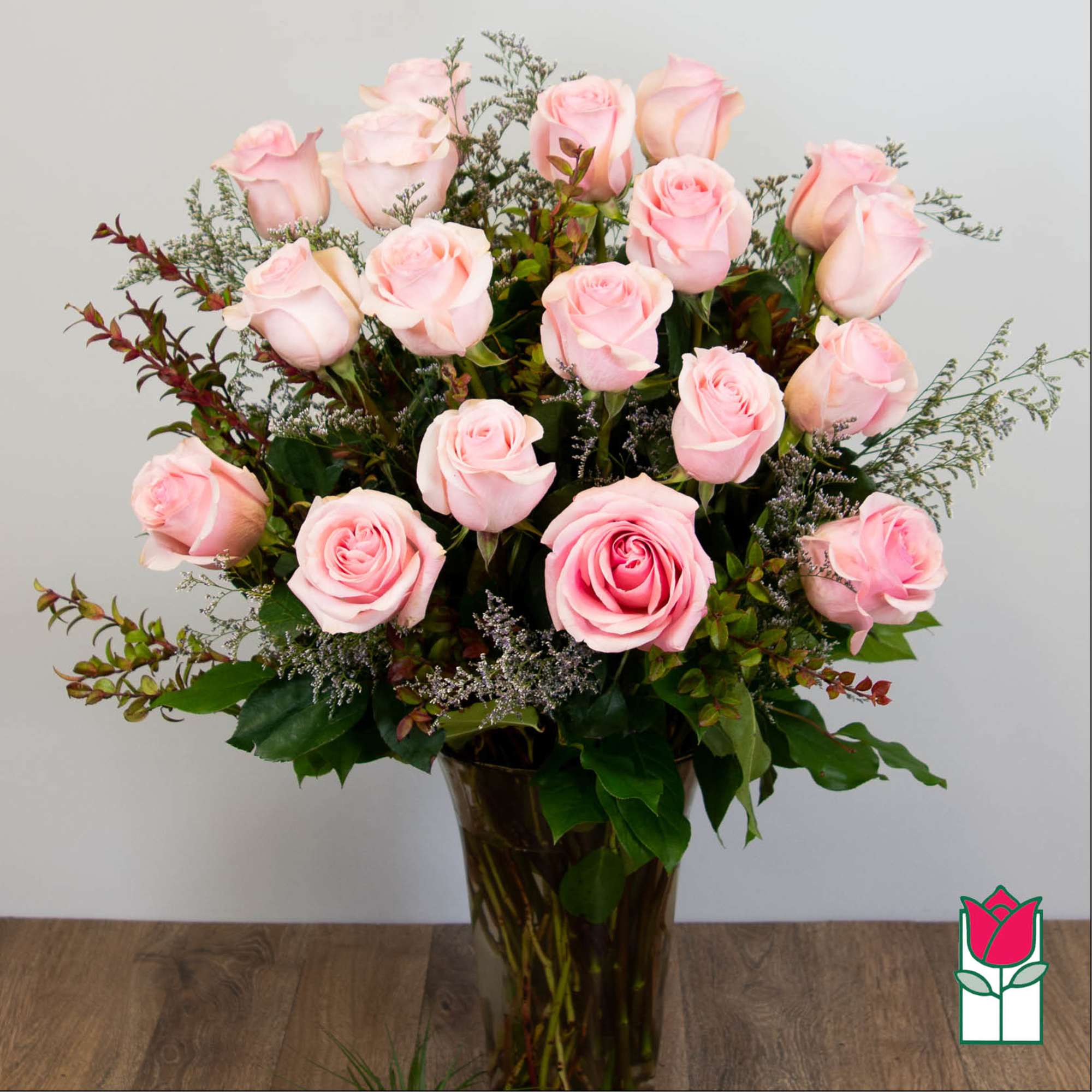Pink roses arranged in a tall glass vase, photo 2 of 5