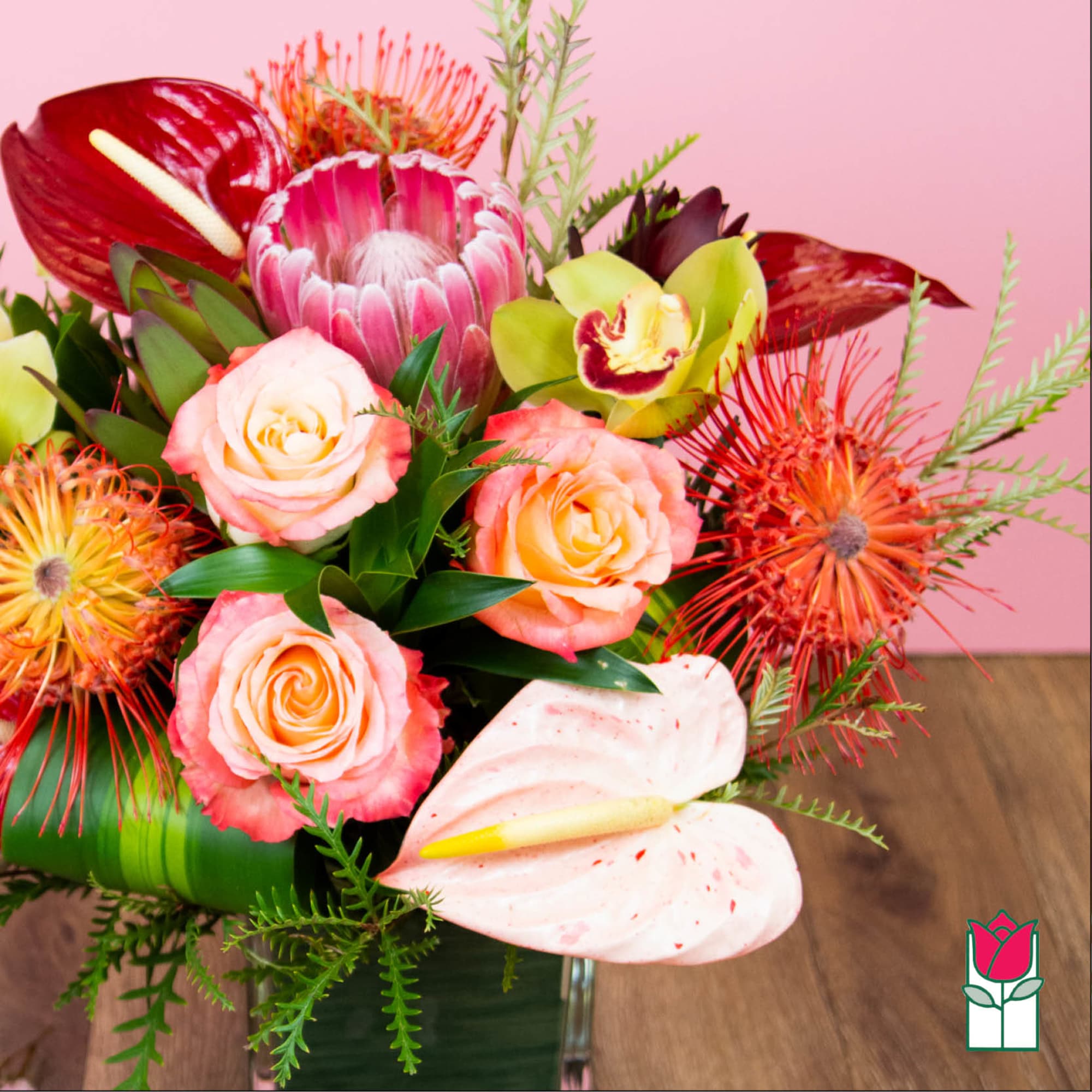 Tropical bouquet with pink roses and anthuriums in a vase