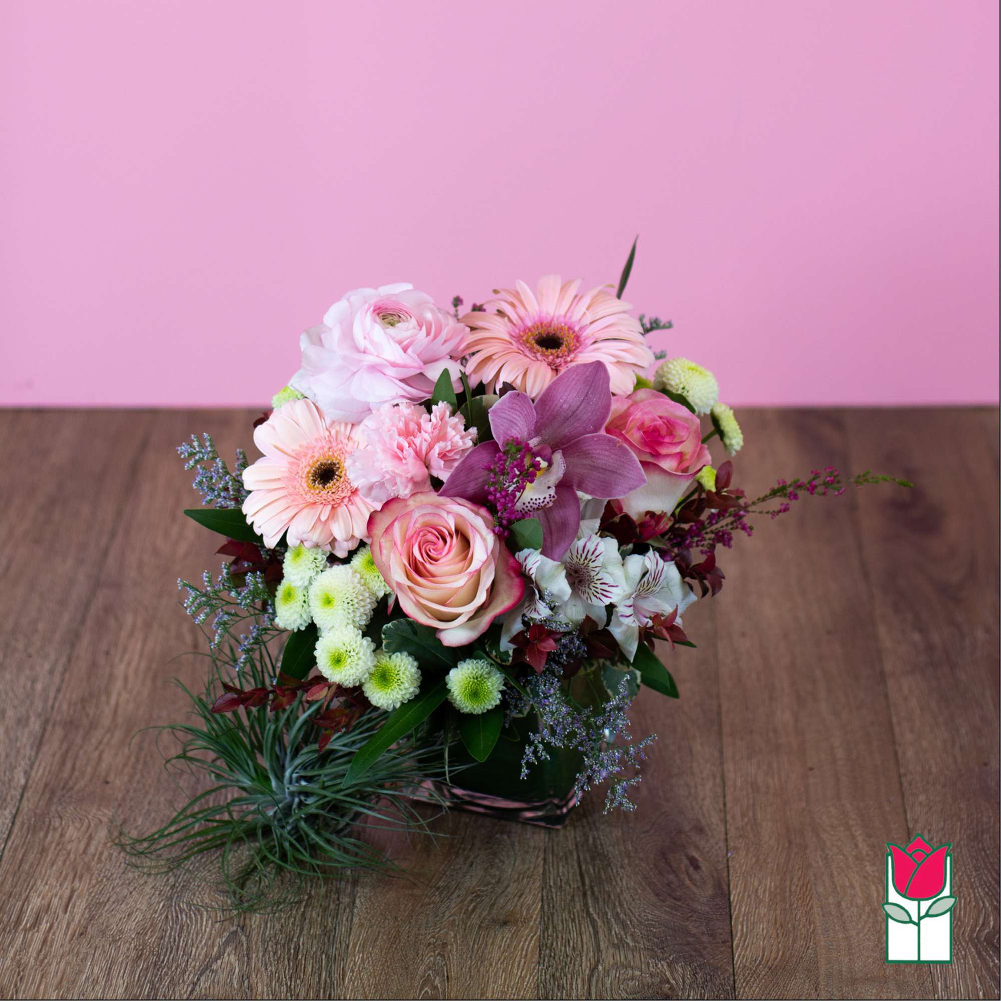Pink and white mixed flower bouquet in a low container