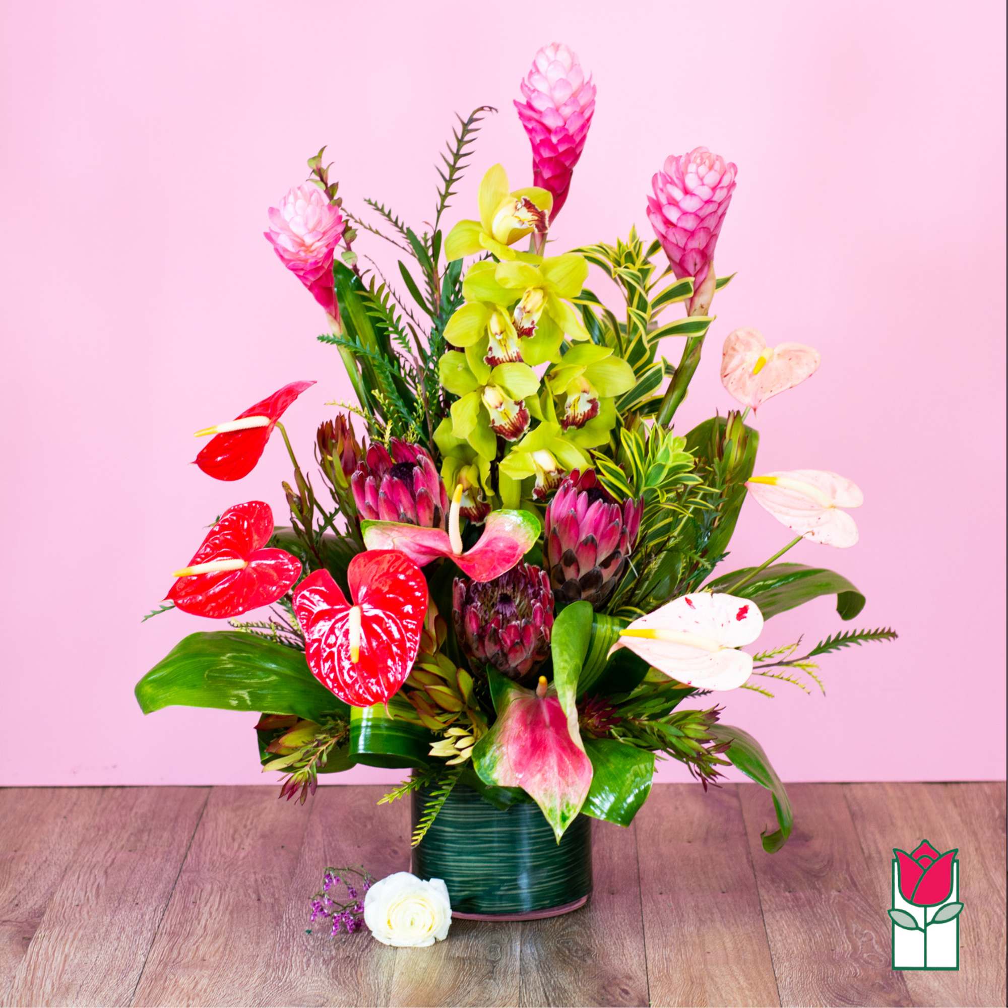 Tropical bouquet with pink ginger, orchids, and red anthuriums in a vase