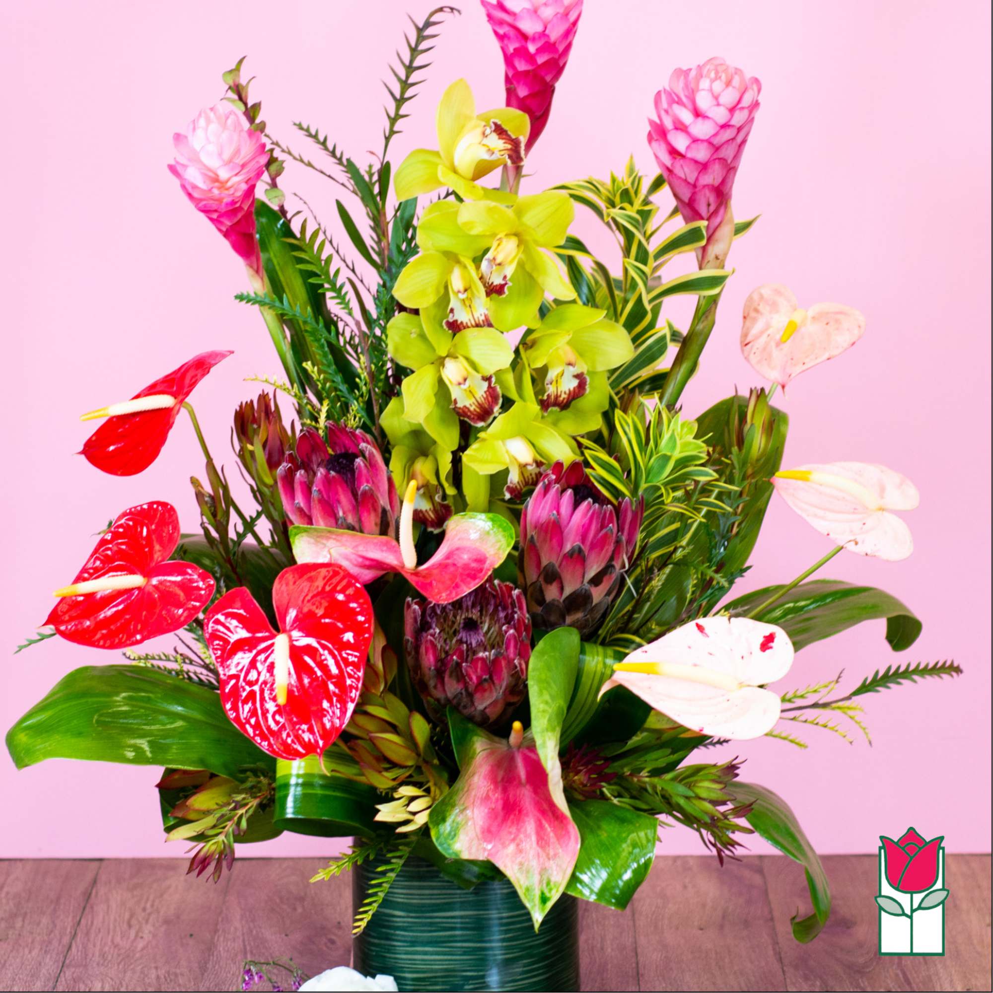 Tropical floral arrangement with anthuriums and orchids in a vase