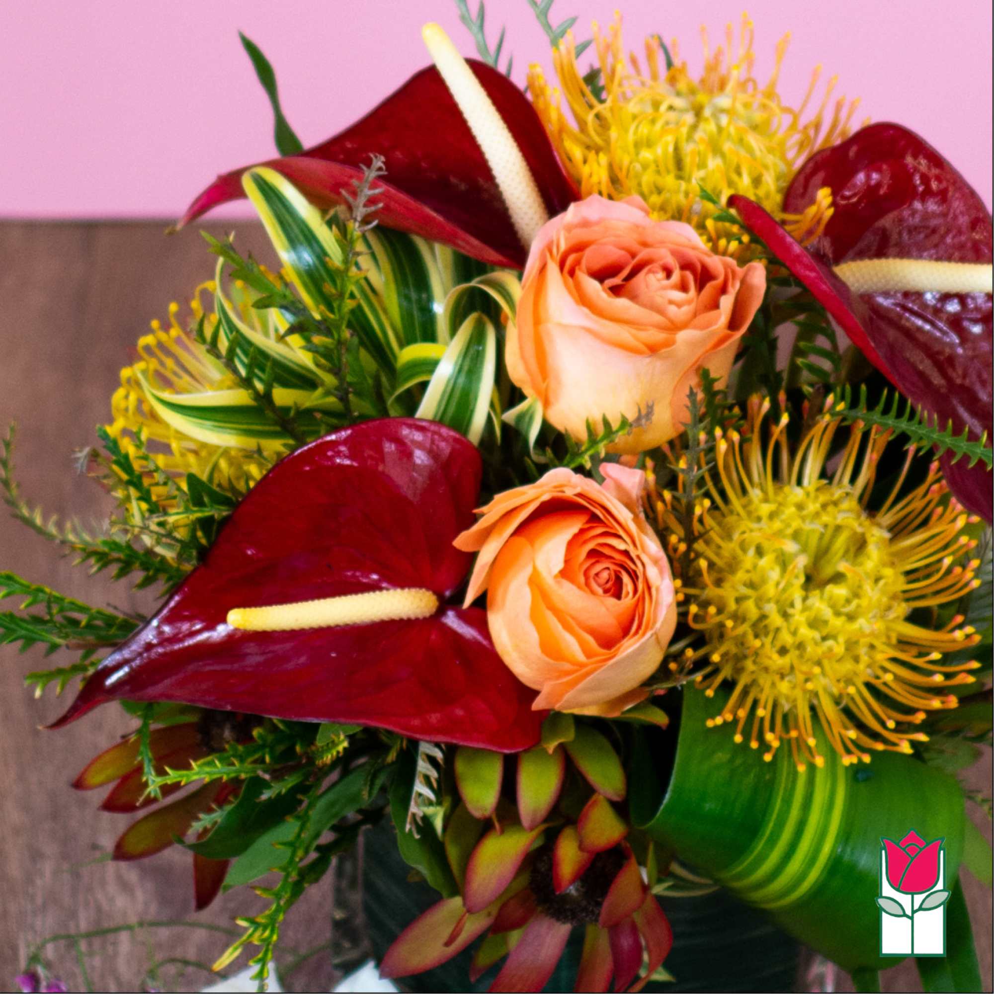 Bouquet with peach roses, burgundy anthuriums, and yellow pincushion blooms
