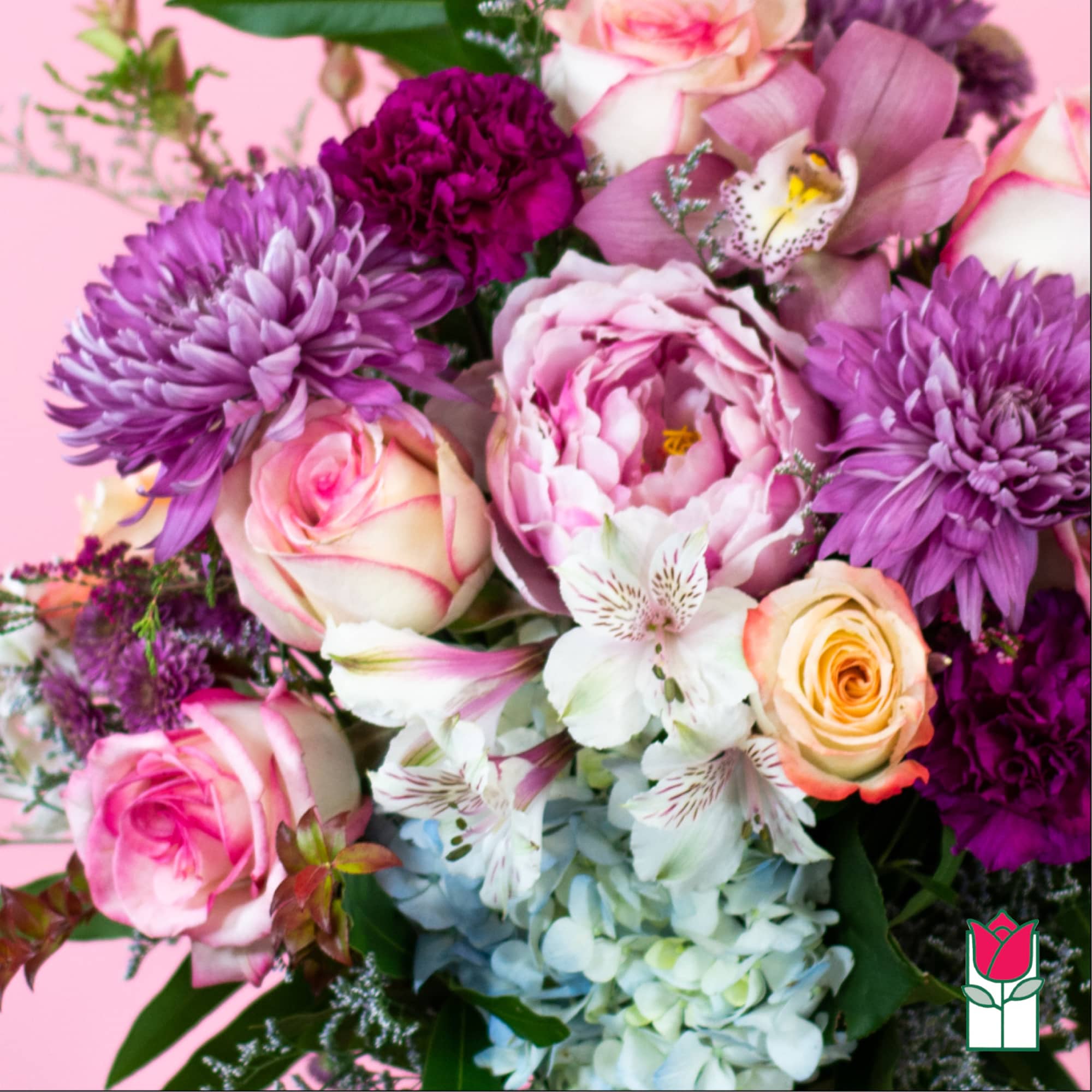 Lush mixed bouquet of pink roses, purple mums, peonies, orchids and white blooms on pink background