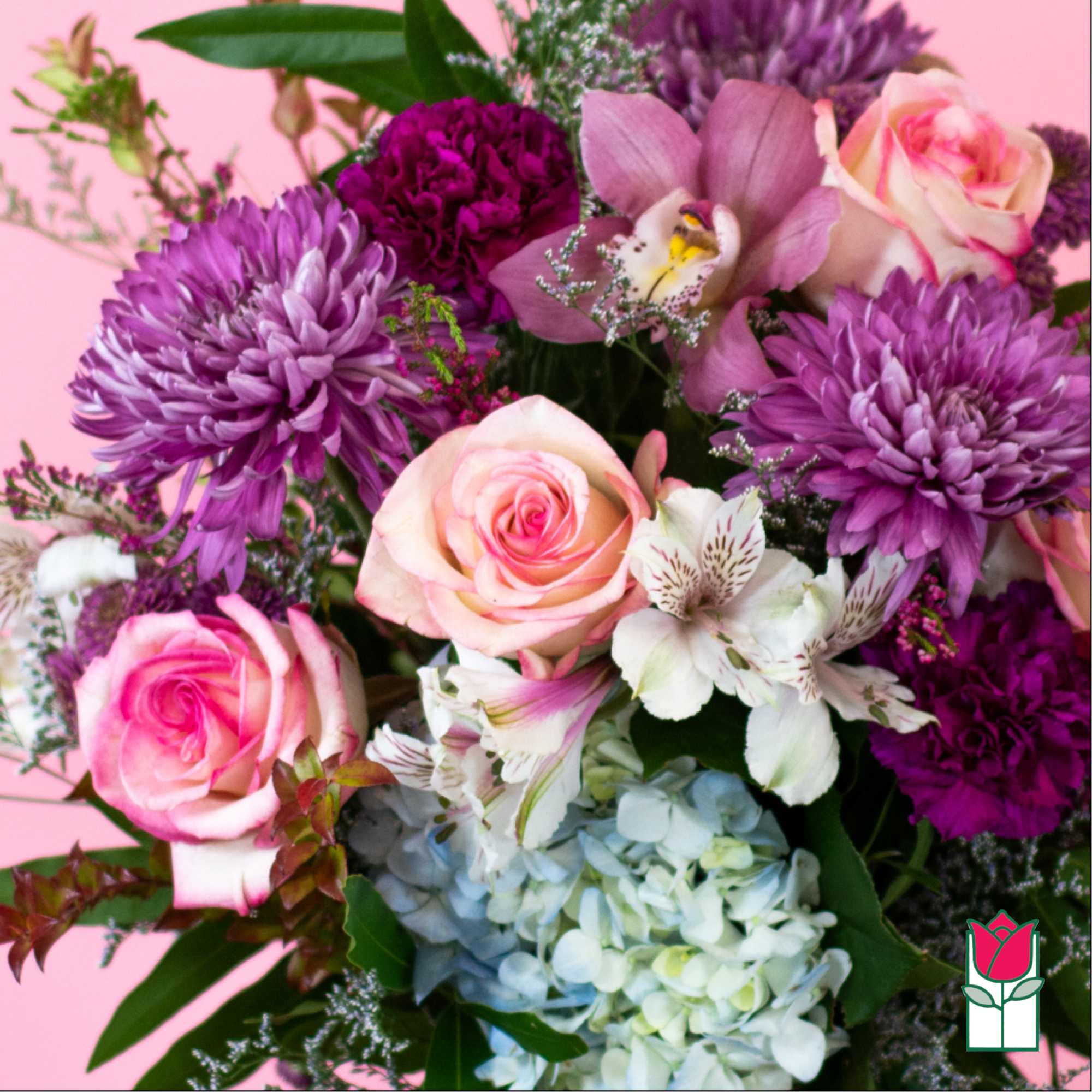 Mixed bouquet of pink roses, purple mums, white alstroemeria, and blue hydrangeas on a pink background