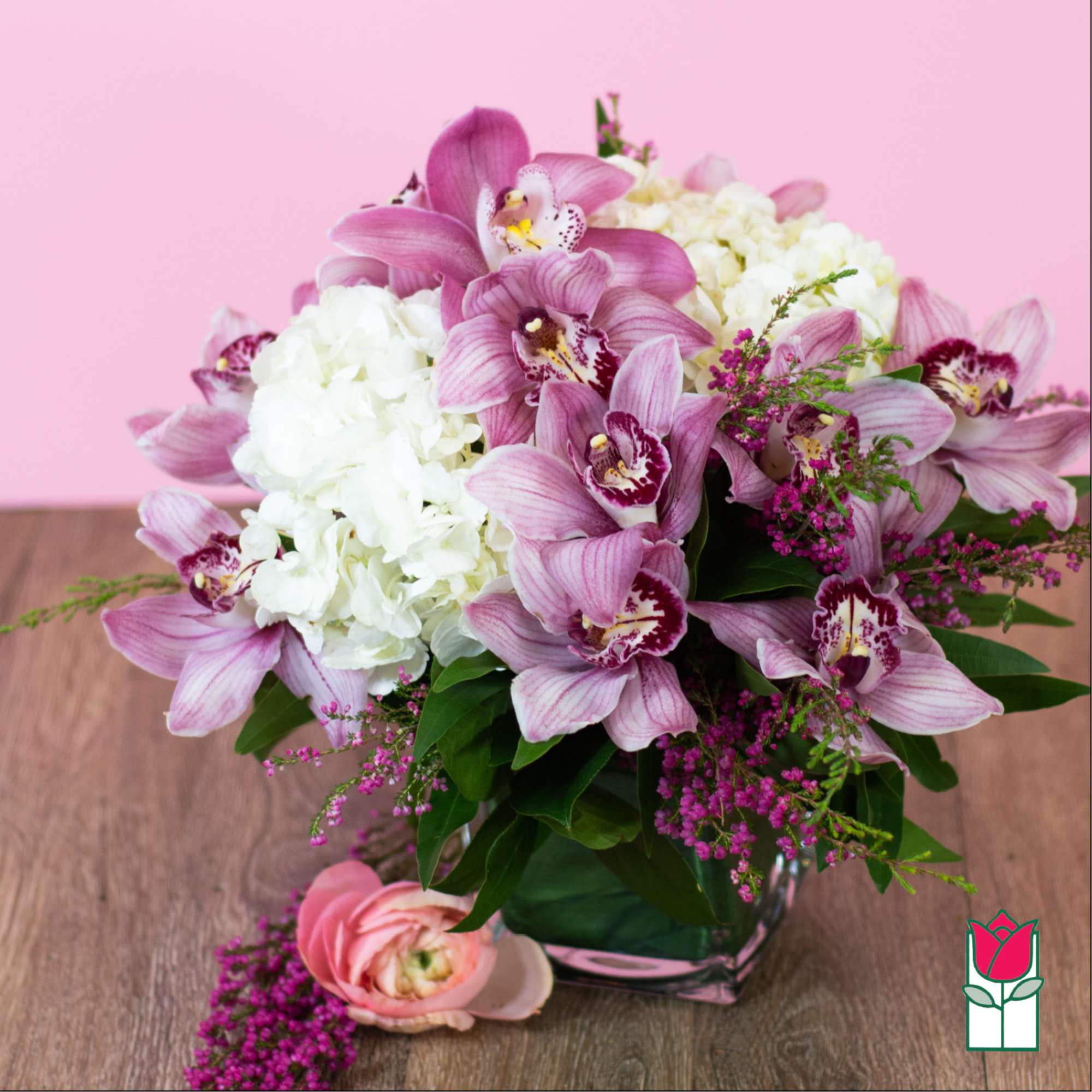 Pink orchids and white hydrangeas in a glass vase with a pink bloom on the table, photo 2 of 5
