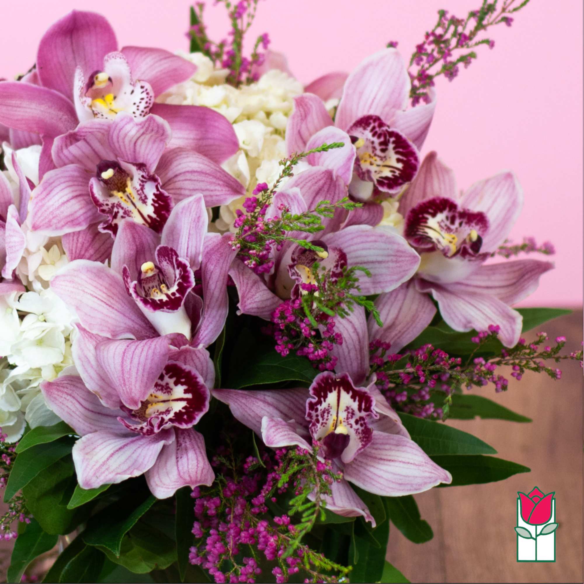 Bouquet of pink orchids and white hydrangeas against a pink background