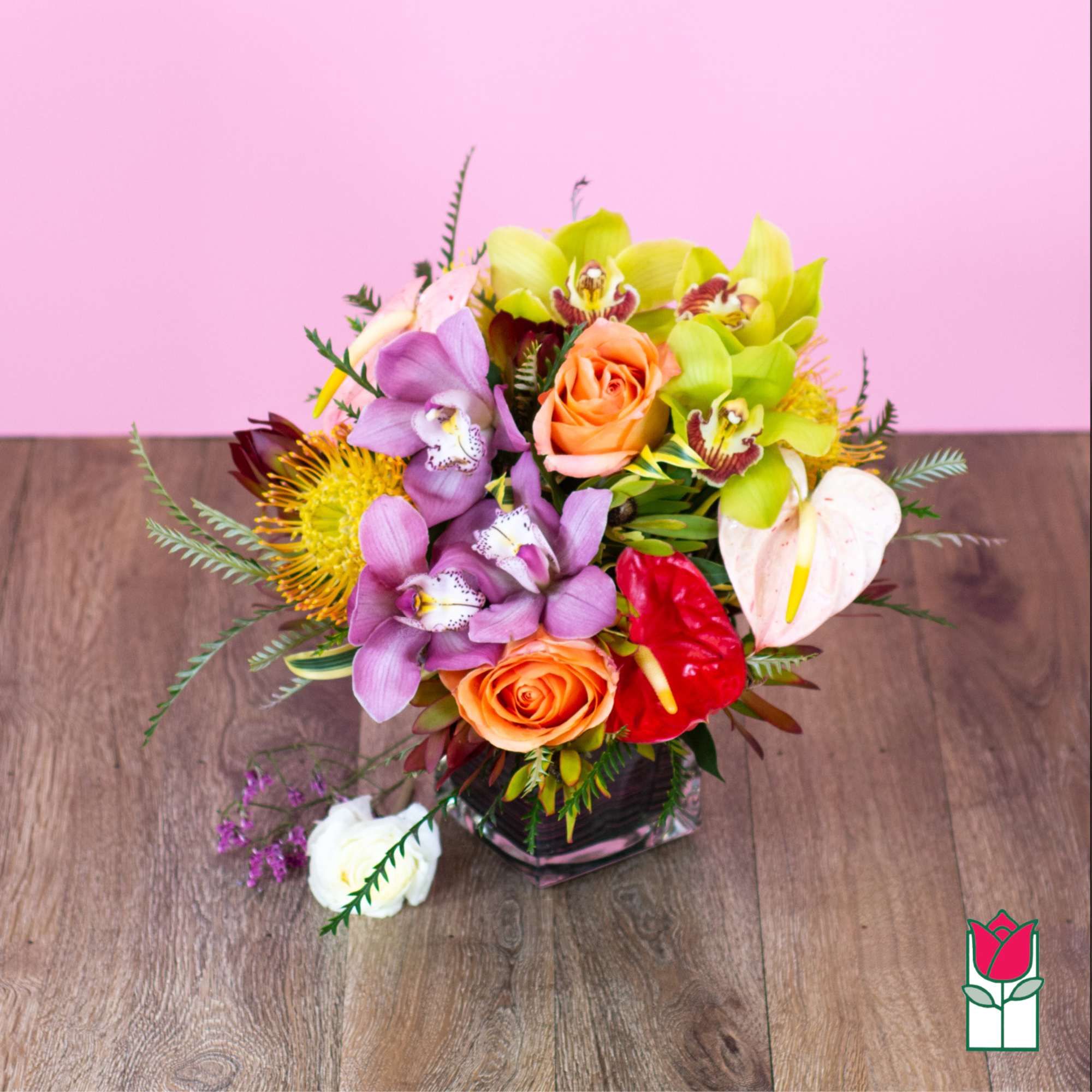 Mixed bouquet with orchids, roses, and anthurium in a glass vase
