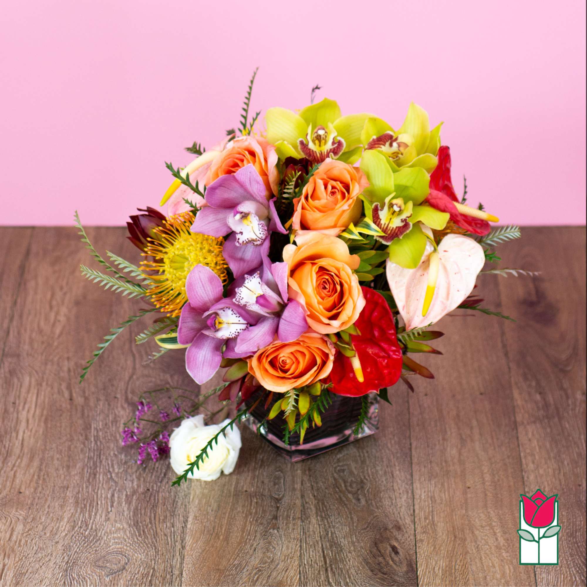 Mixed bouquet with roses, orchids, and anthuriums in a glass vase
