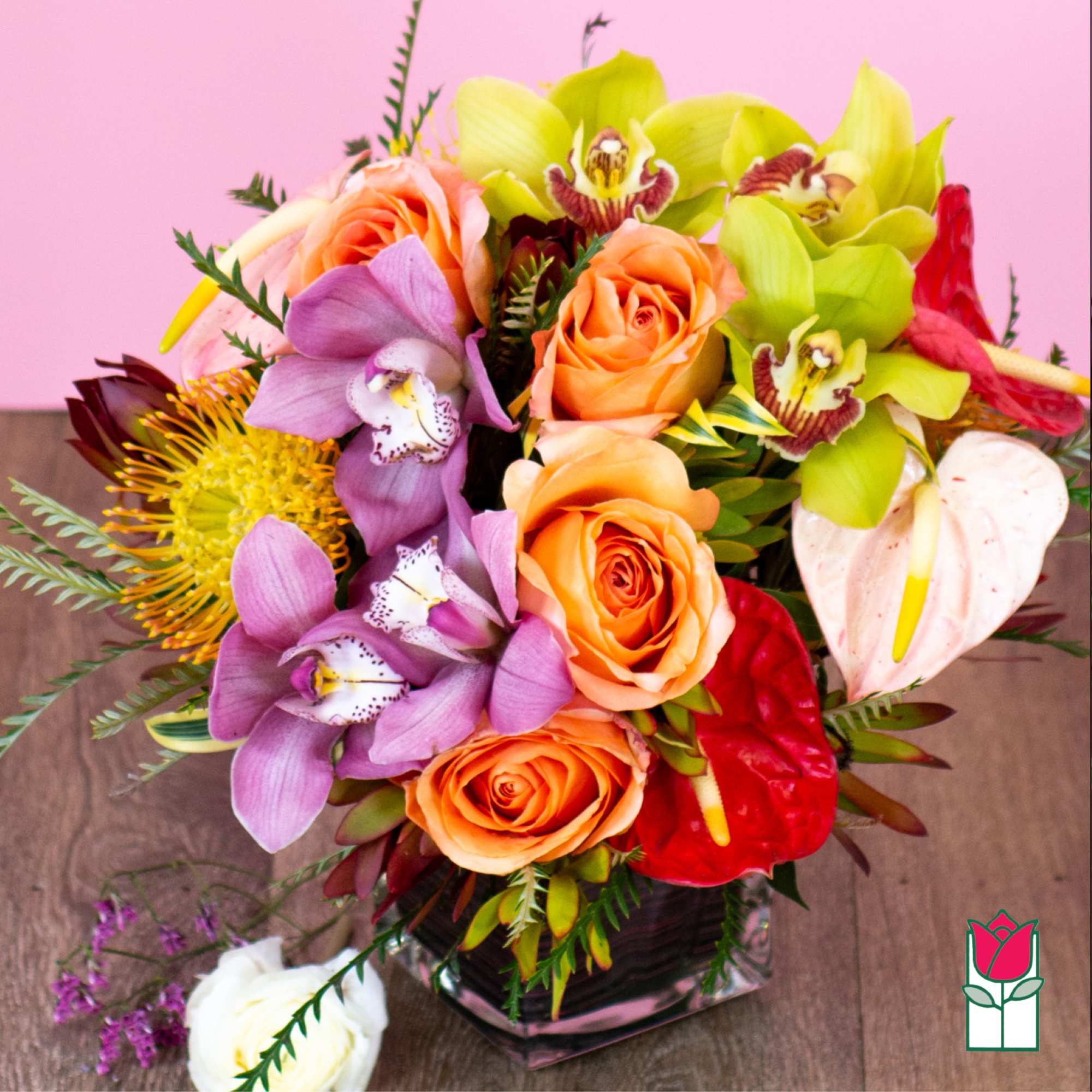 Colorful bouquet of roses and orchids in a glass vase