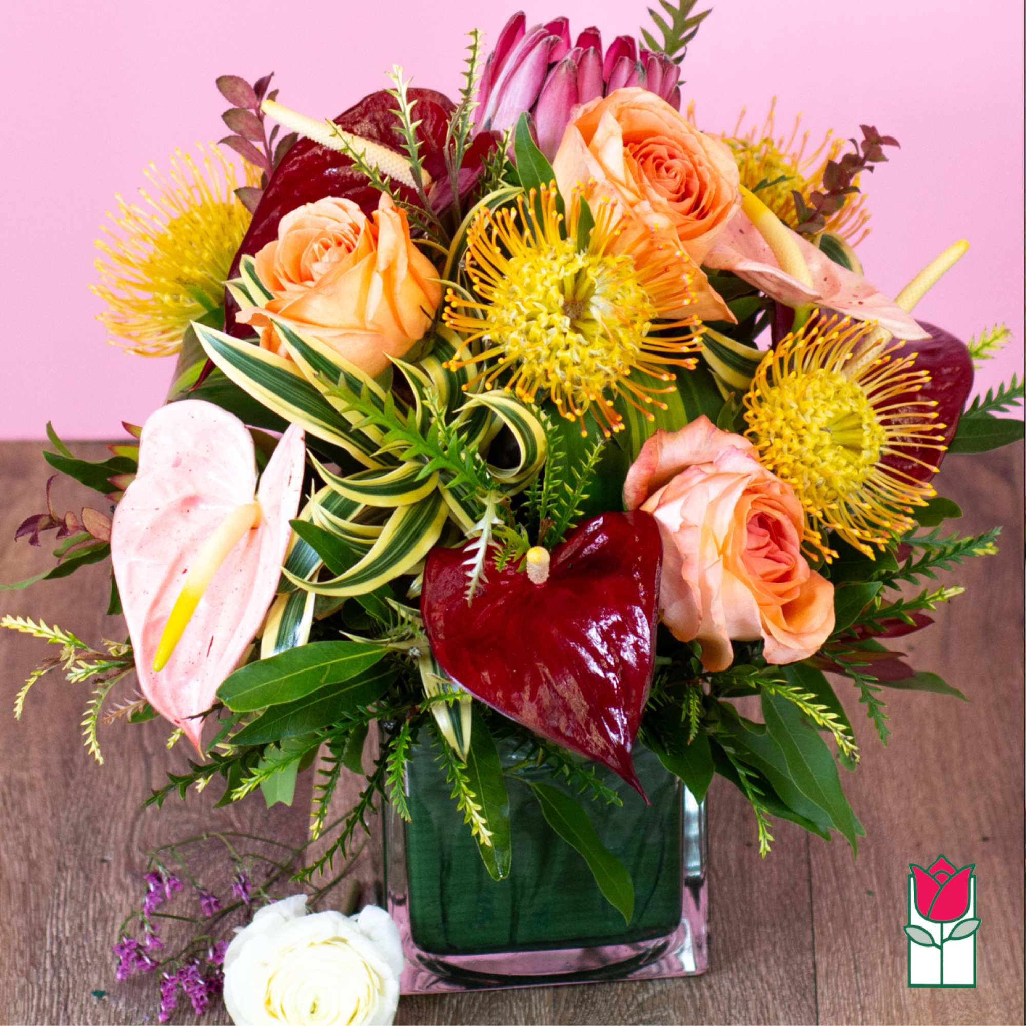 Bouquet of peach roses and tropical flowers in a glass vase