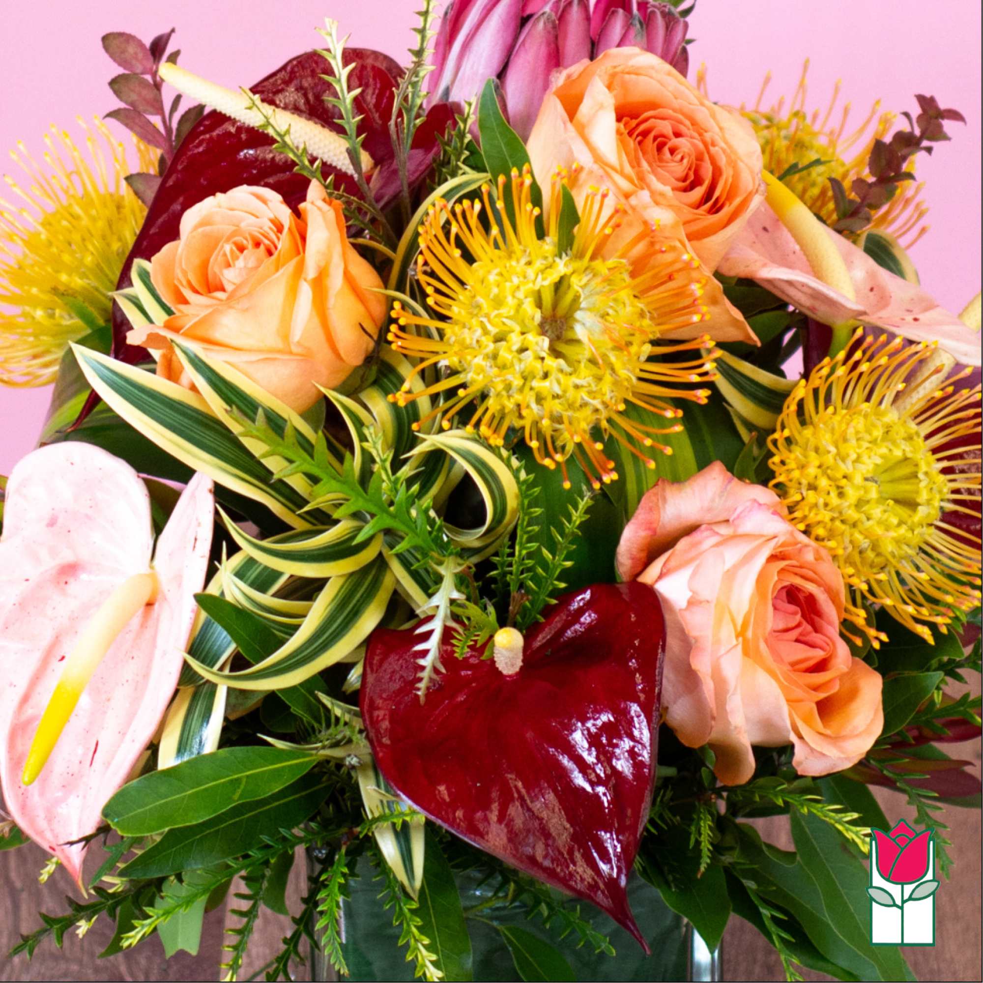 Bouquet of peach roses and yellow pincushion blooms with burgundy anthuriums