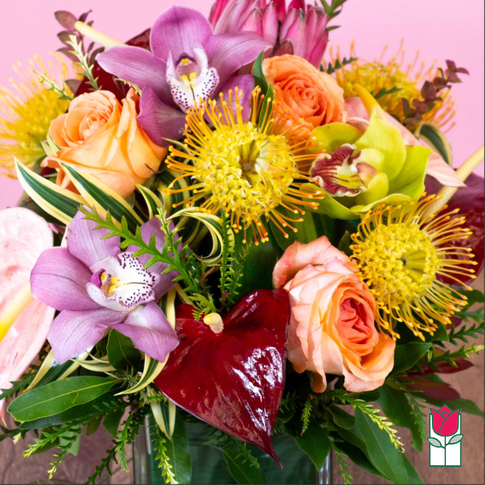 Bouquet of peach roses, purple orchids, and yellow blooms in a vase