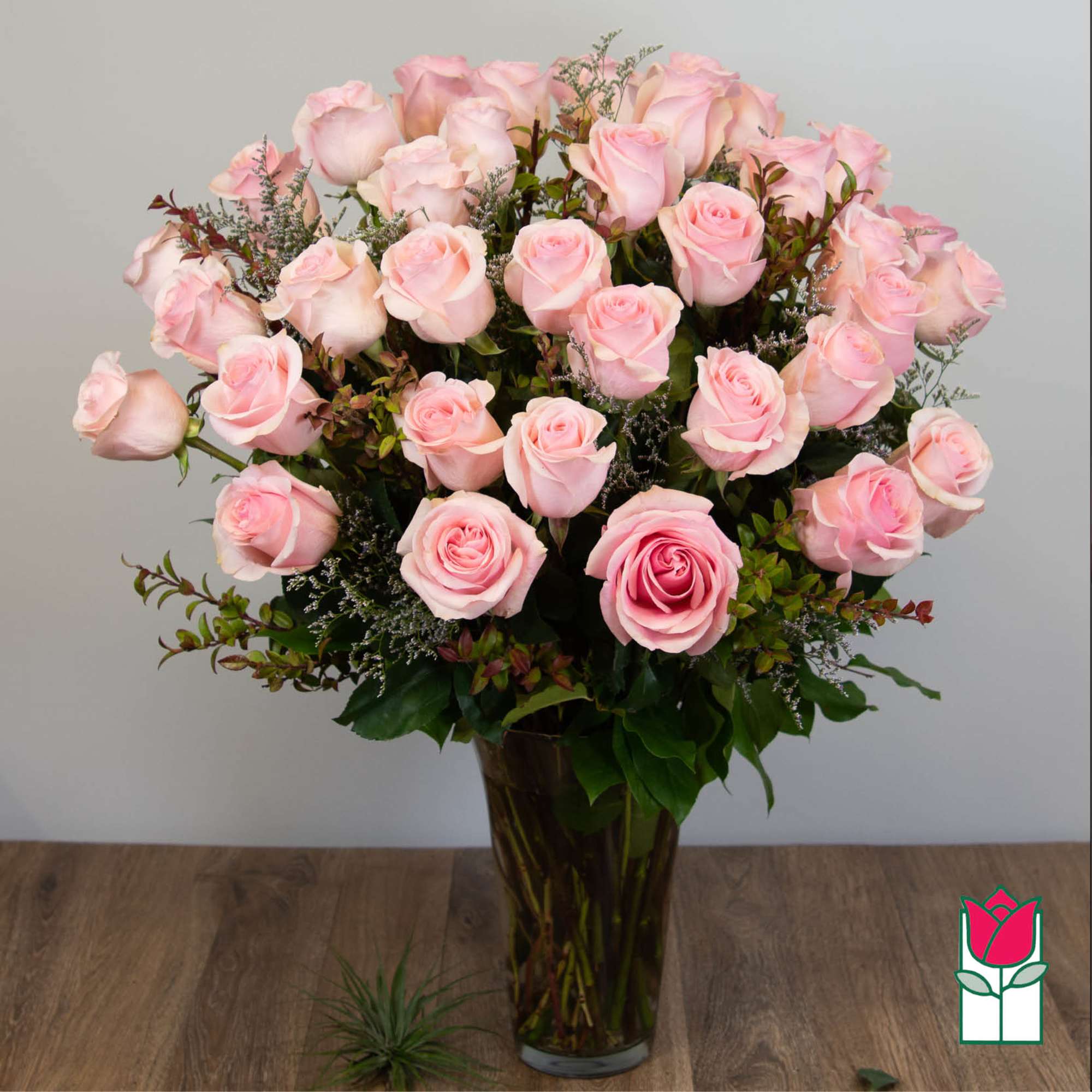 Bouquet of pale pink roses in a tall glass vase