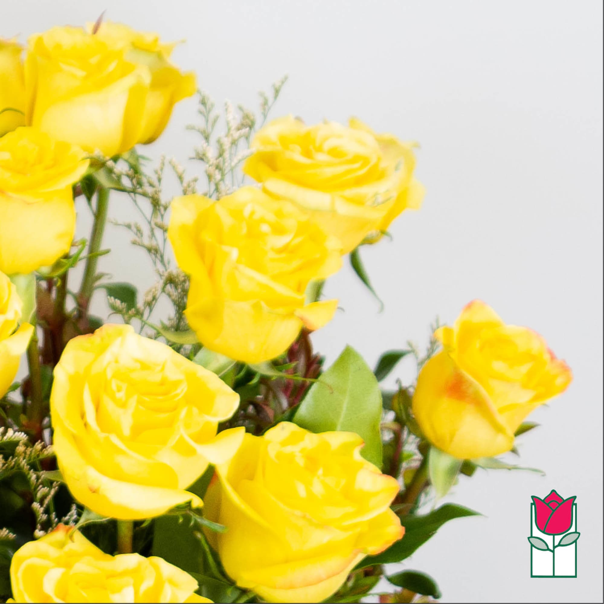 Bouquet of yellow roses with greenery against a light background