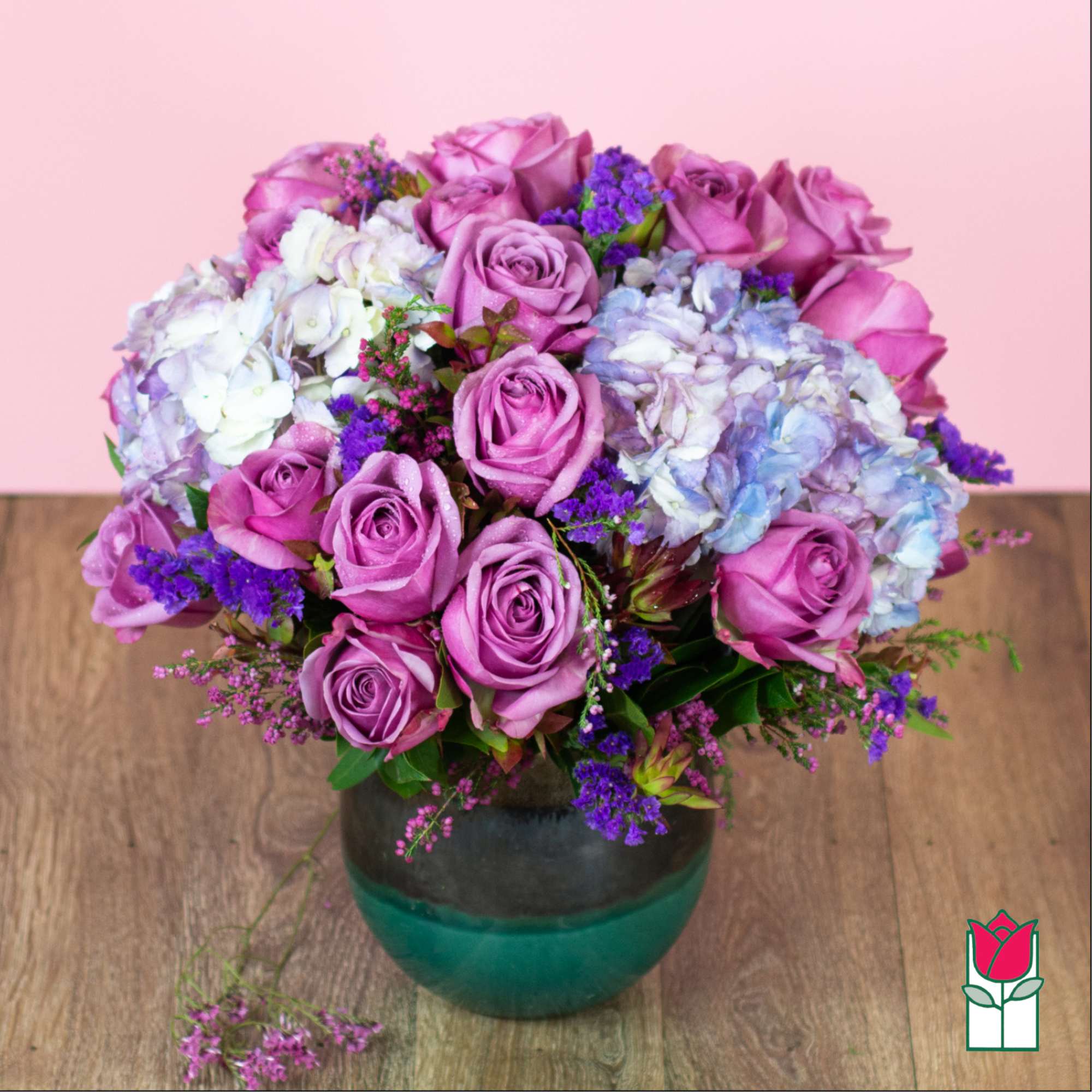 Pink and lavender roses with hydrangeas in a glass vase