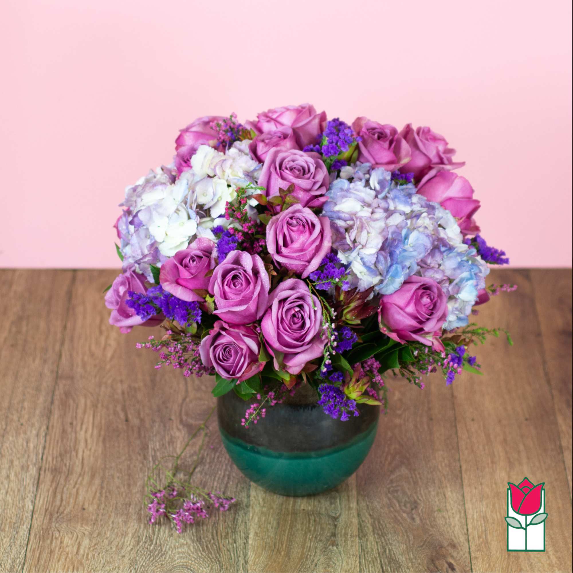 Pink roses and hydrangeas arranged in a glass vase