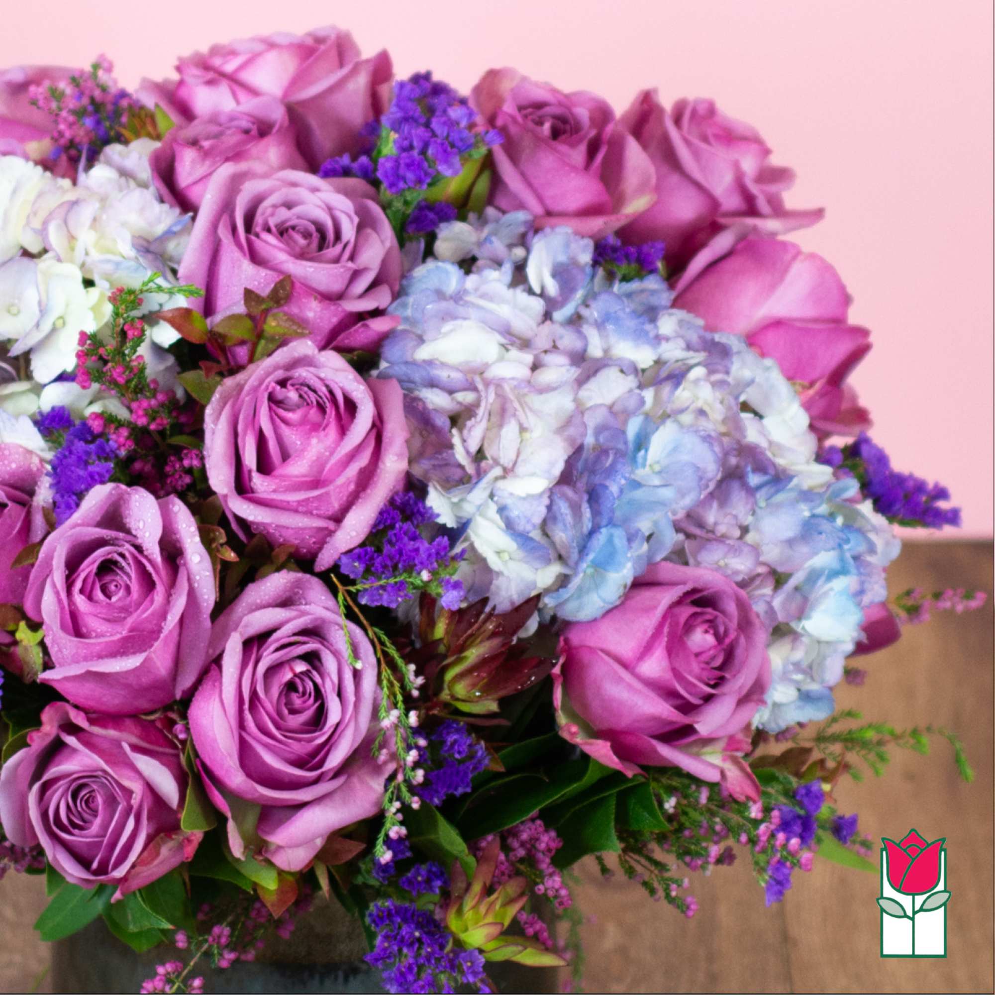 Bouquet of pink roses and blue hydrangeas with purple filler flowers
