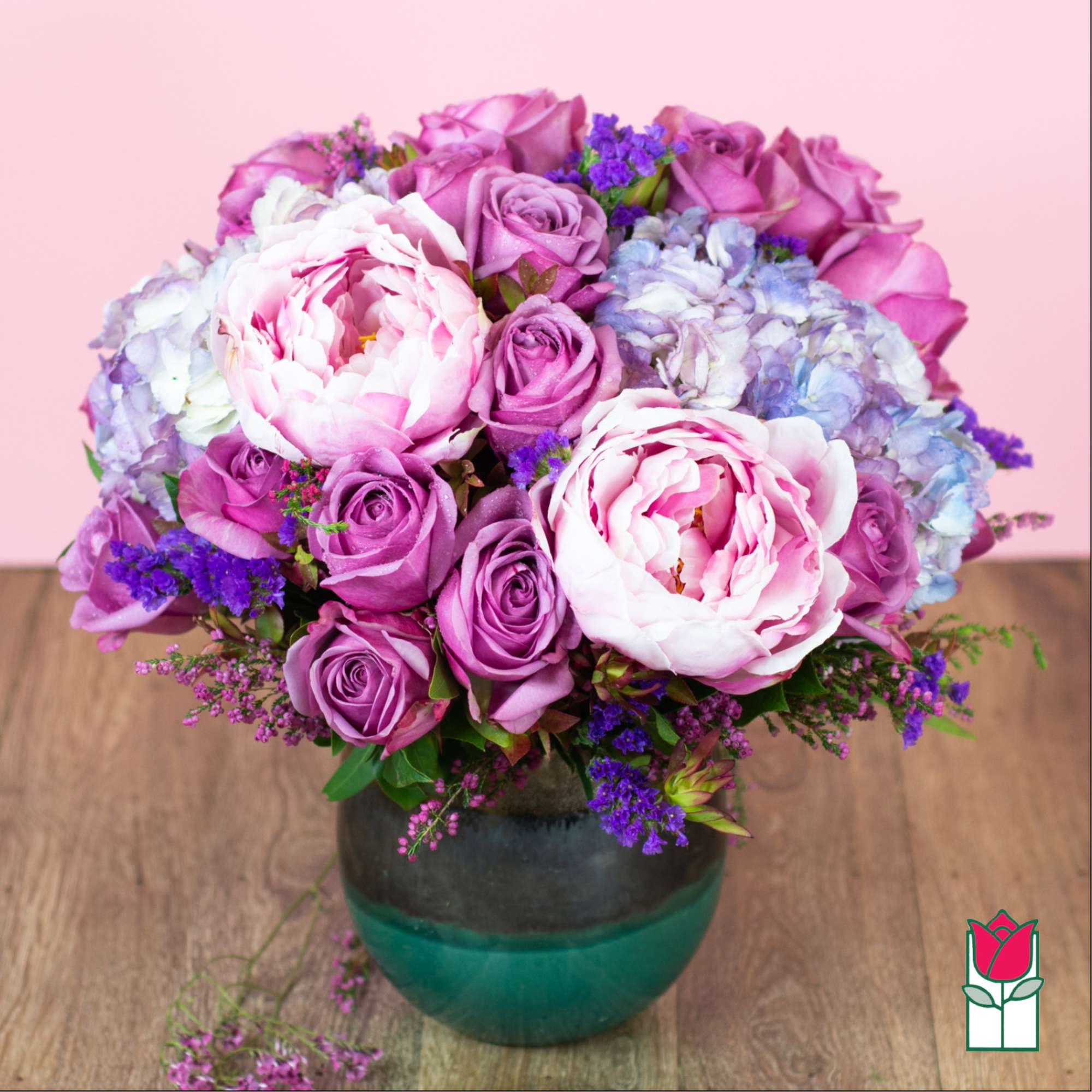 Pink and purple bouquet of roses and peonies in a glass vase