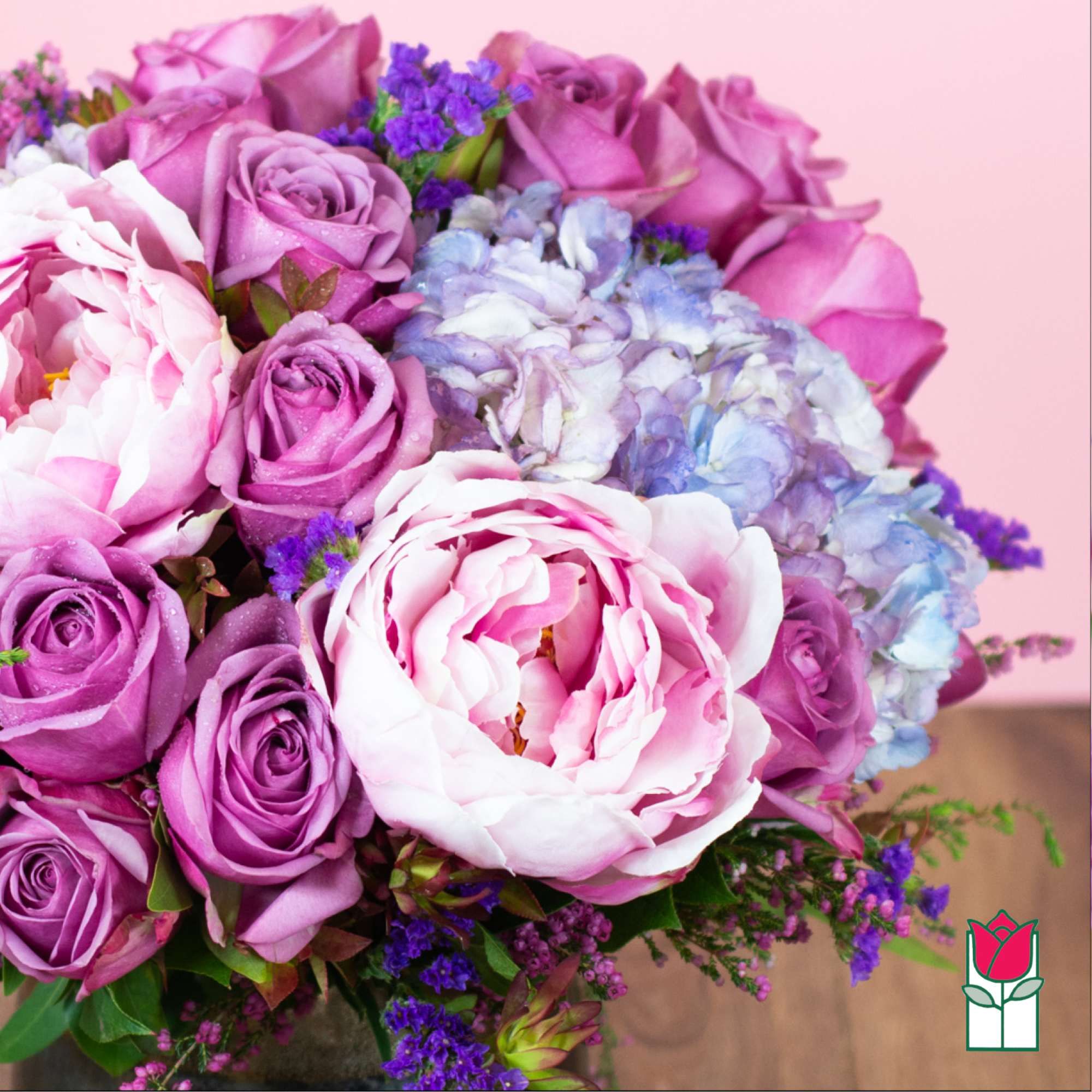 Bouquet of pink and purple roses with pale blue hydrangeas