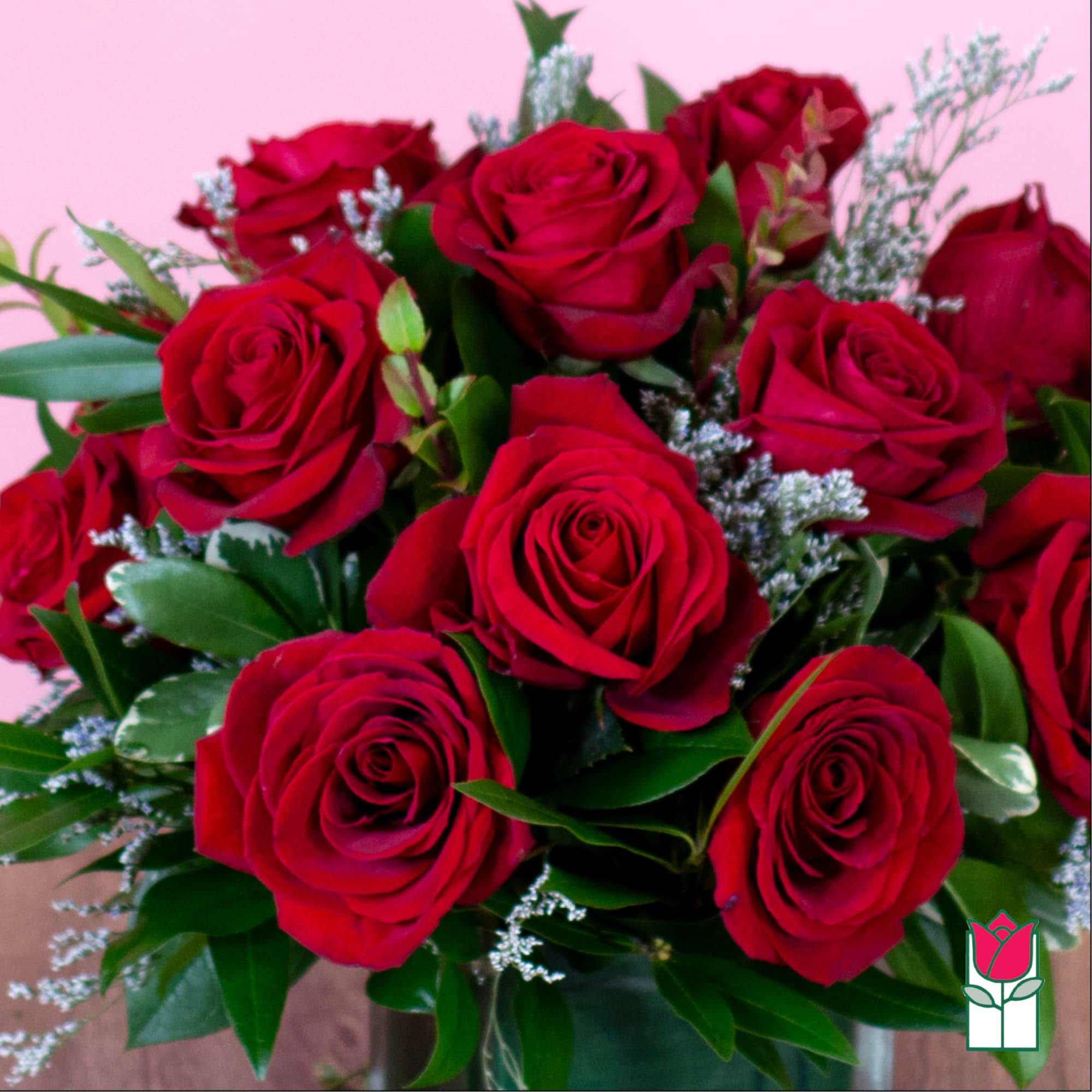 Bouquet of red roses with greenery in a vase