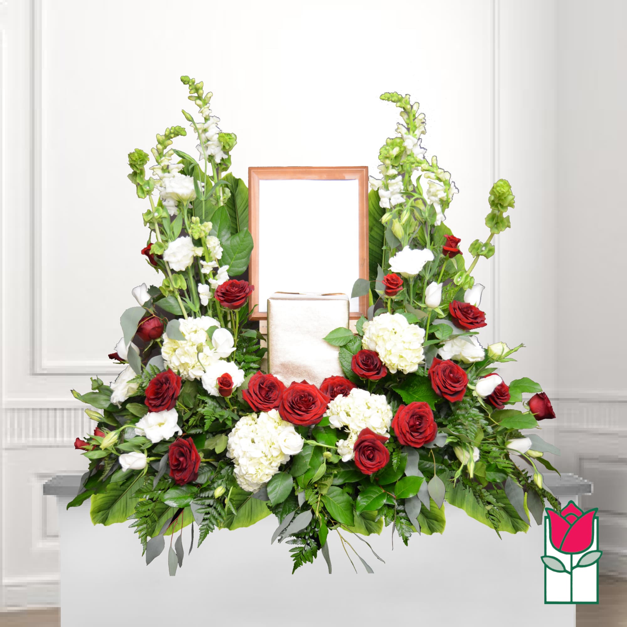 Symmetrical red and white floral funeral display with a framed center