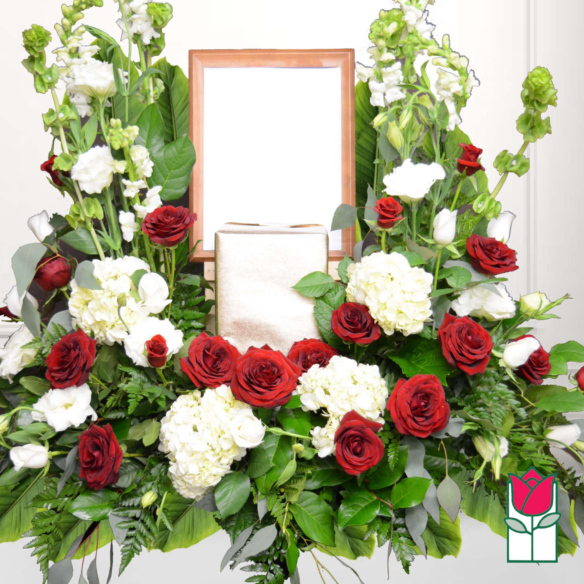 Red roses and white hydrangeas arranged around a framed centerpiece