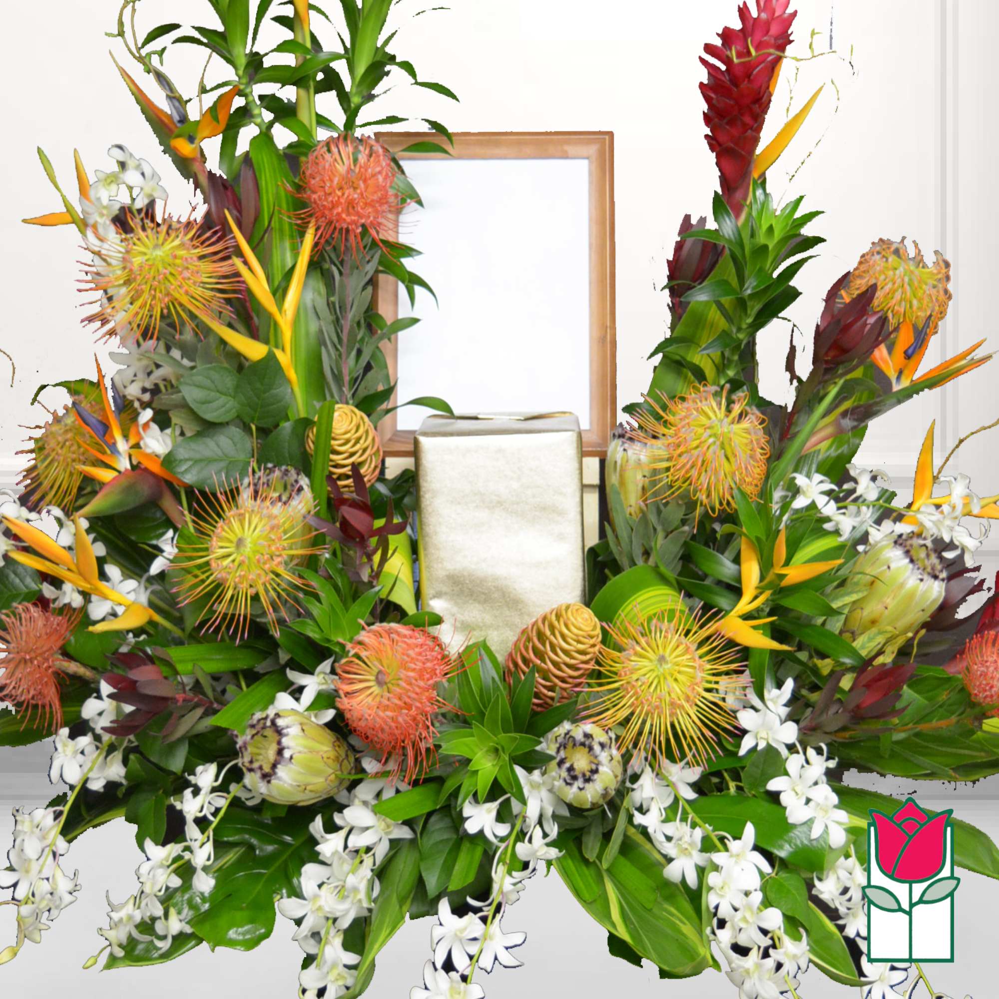 Tropical floral arrangement with orange and white blooms around a gold gift box