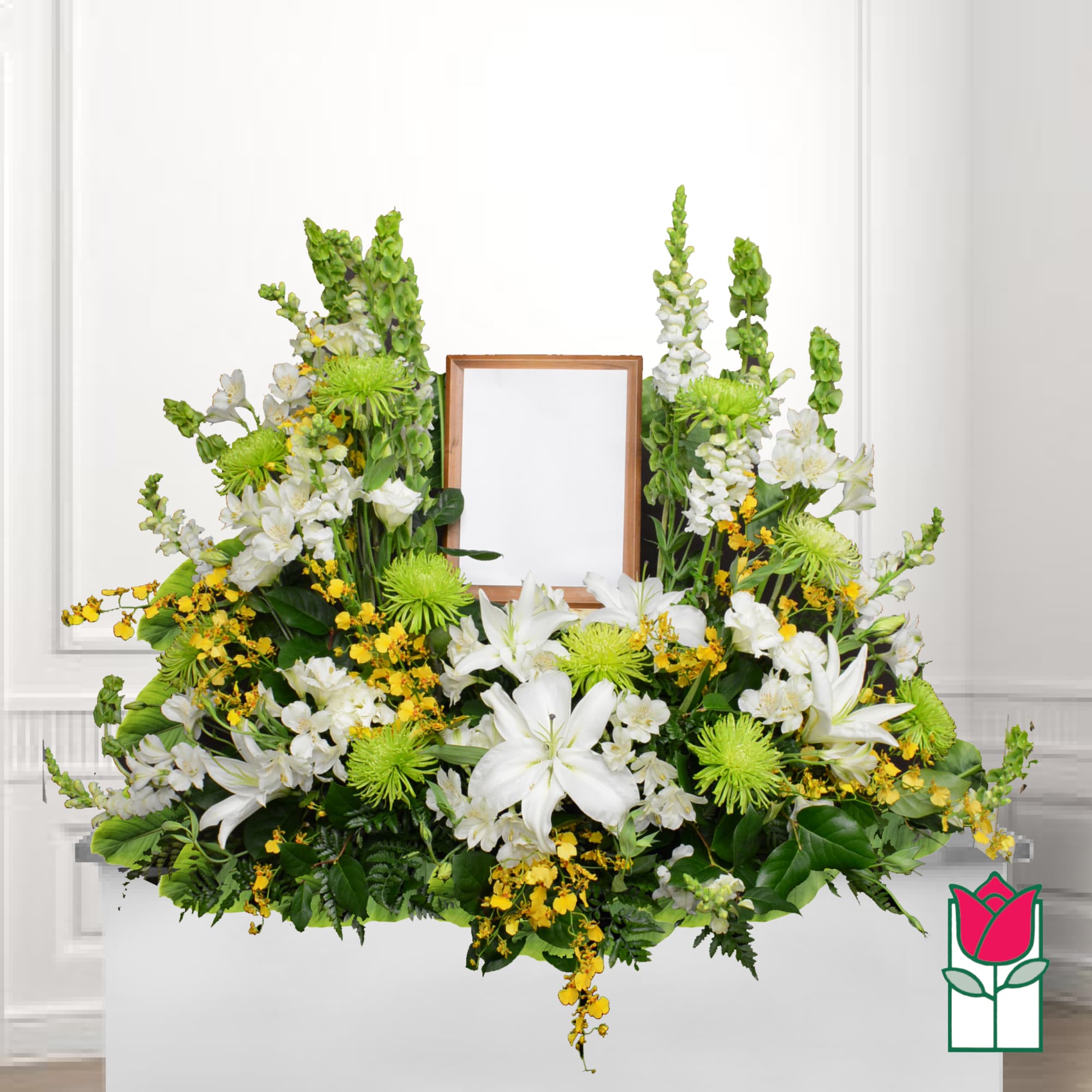 Large white and green floral funeral spray with a framed center