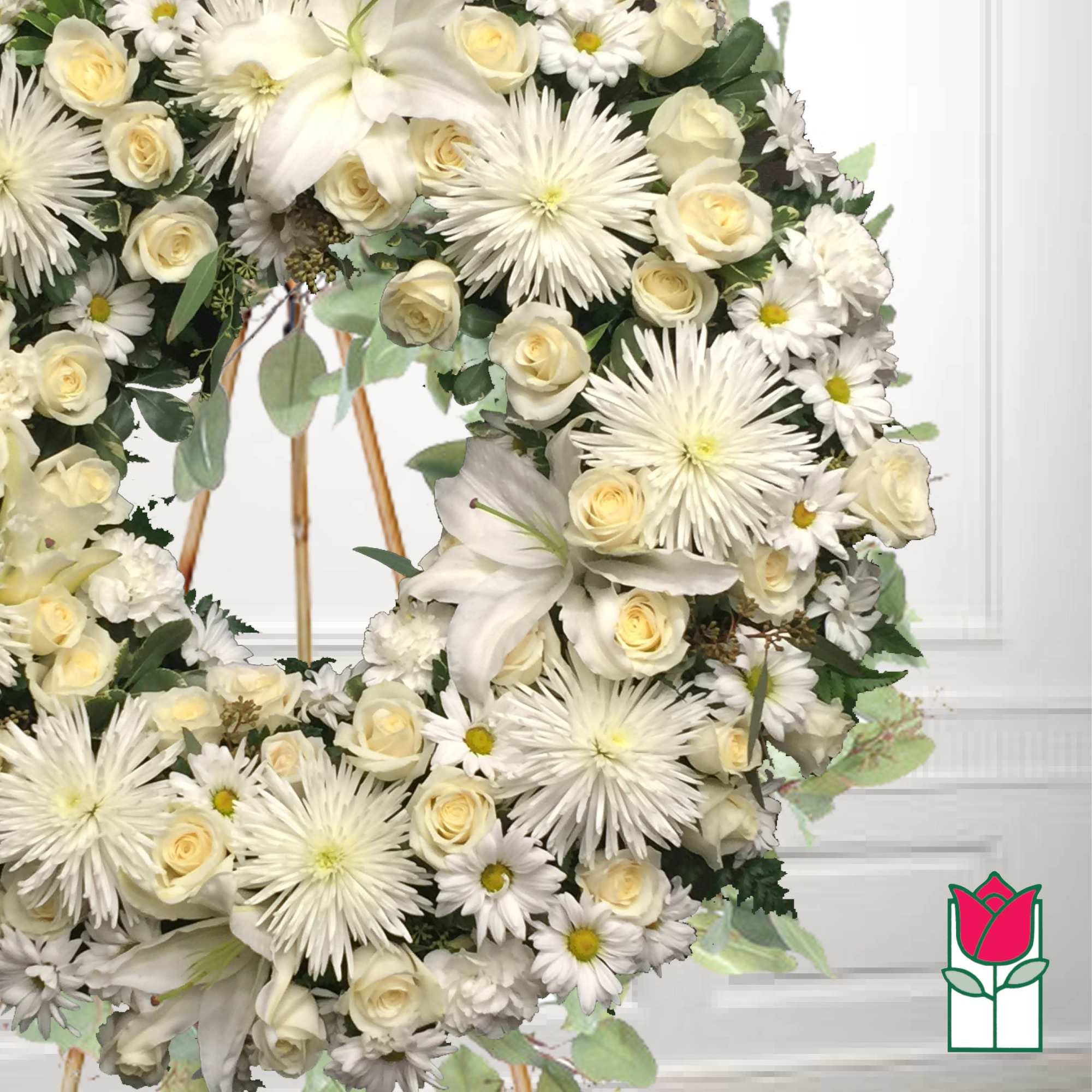 White floral wreath with roses, lilies, and daisy-like blooms