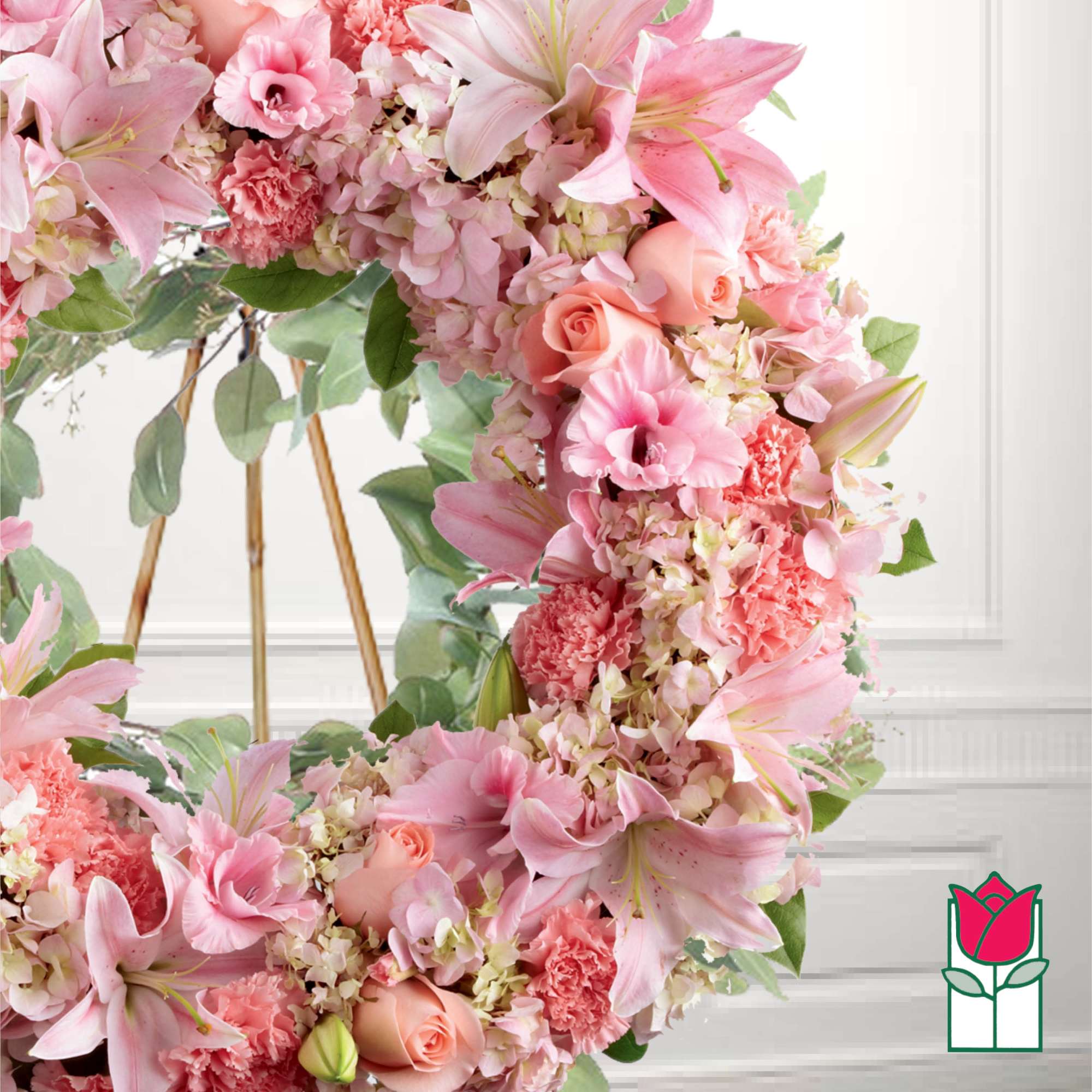 Pink floral wreath with lilies, roses, and carnations