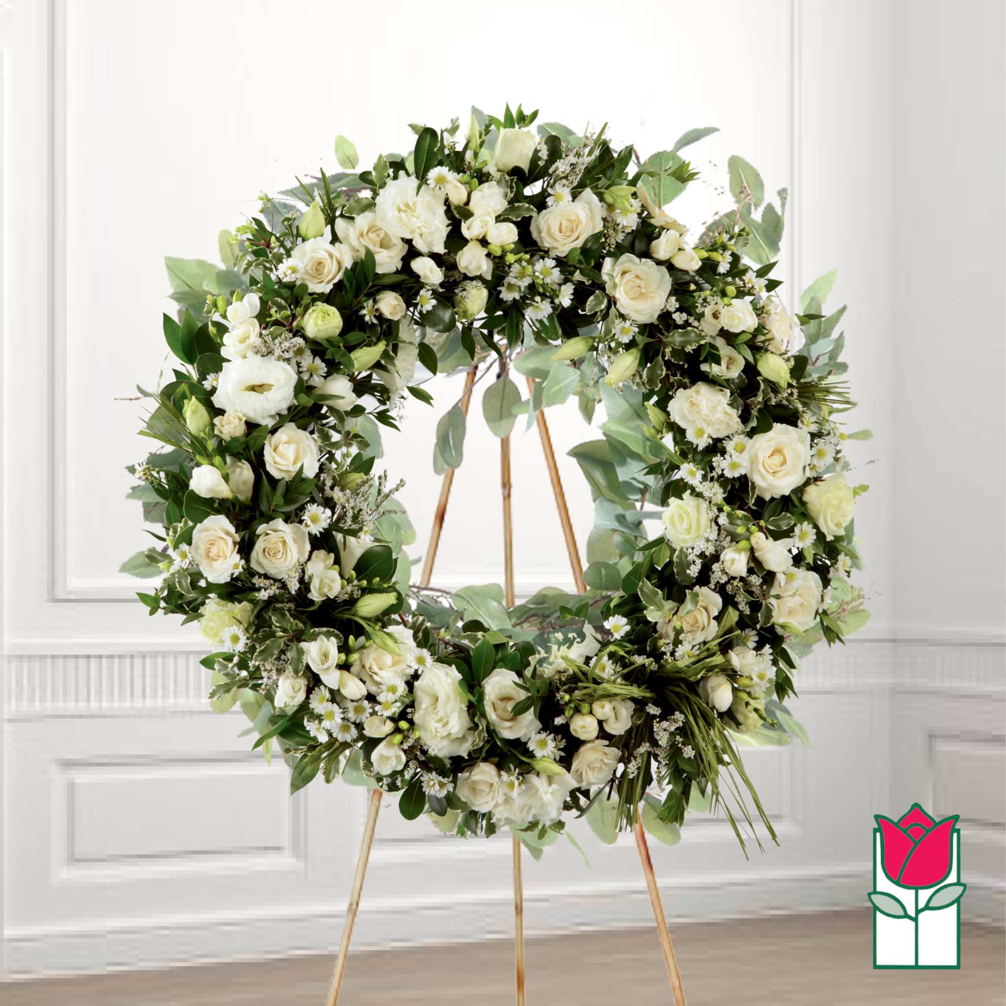 Large white floral wreath on a gold stand