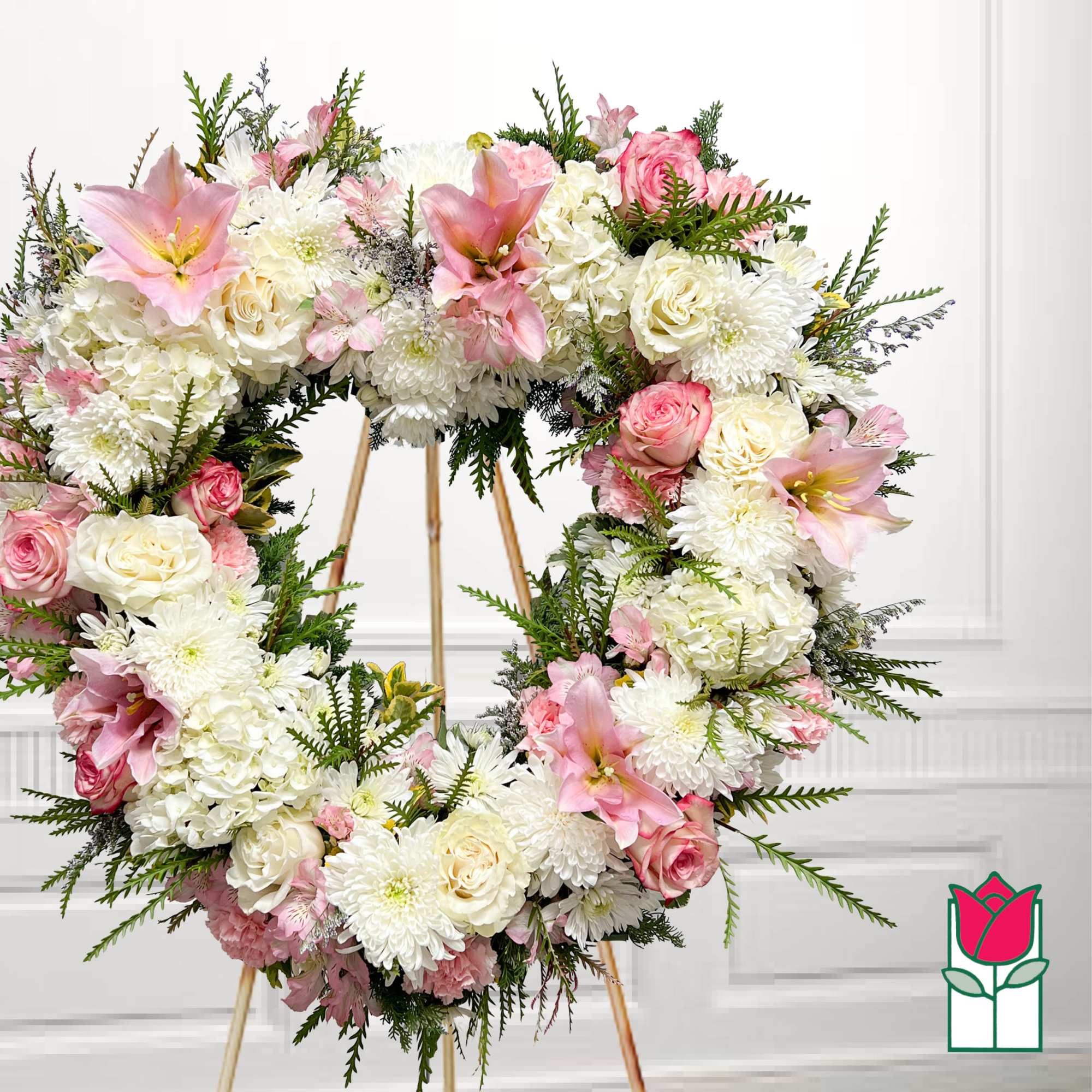 Heart-shaped floral wreath with pink and white flowers on a stand
