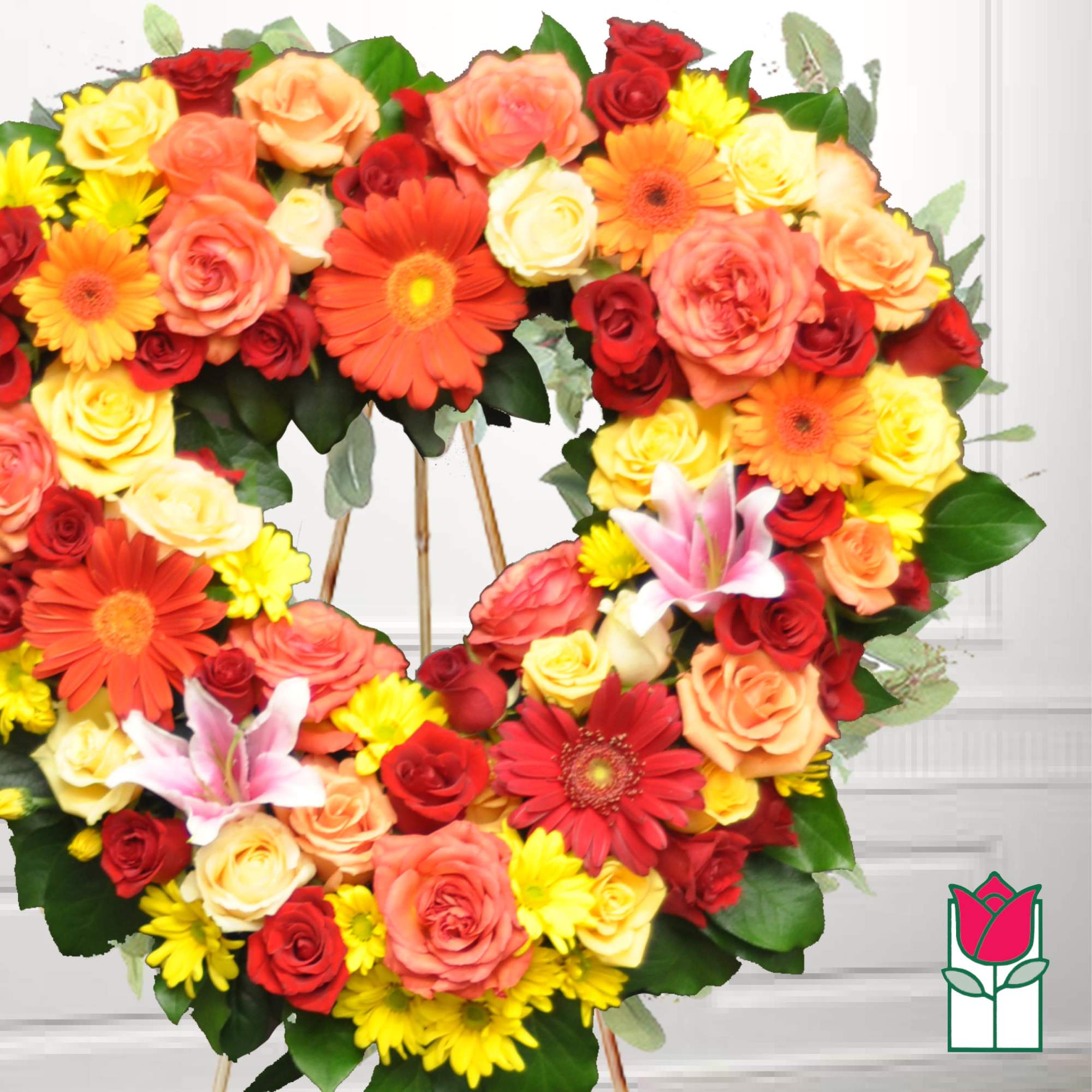Heart-shaped floral wreath with roses, gerbera daisies, lilies, and chrysanthemums