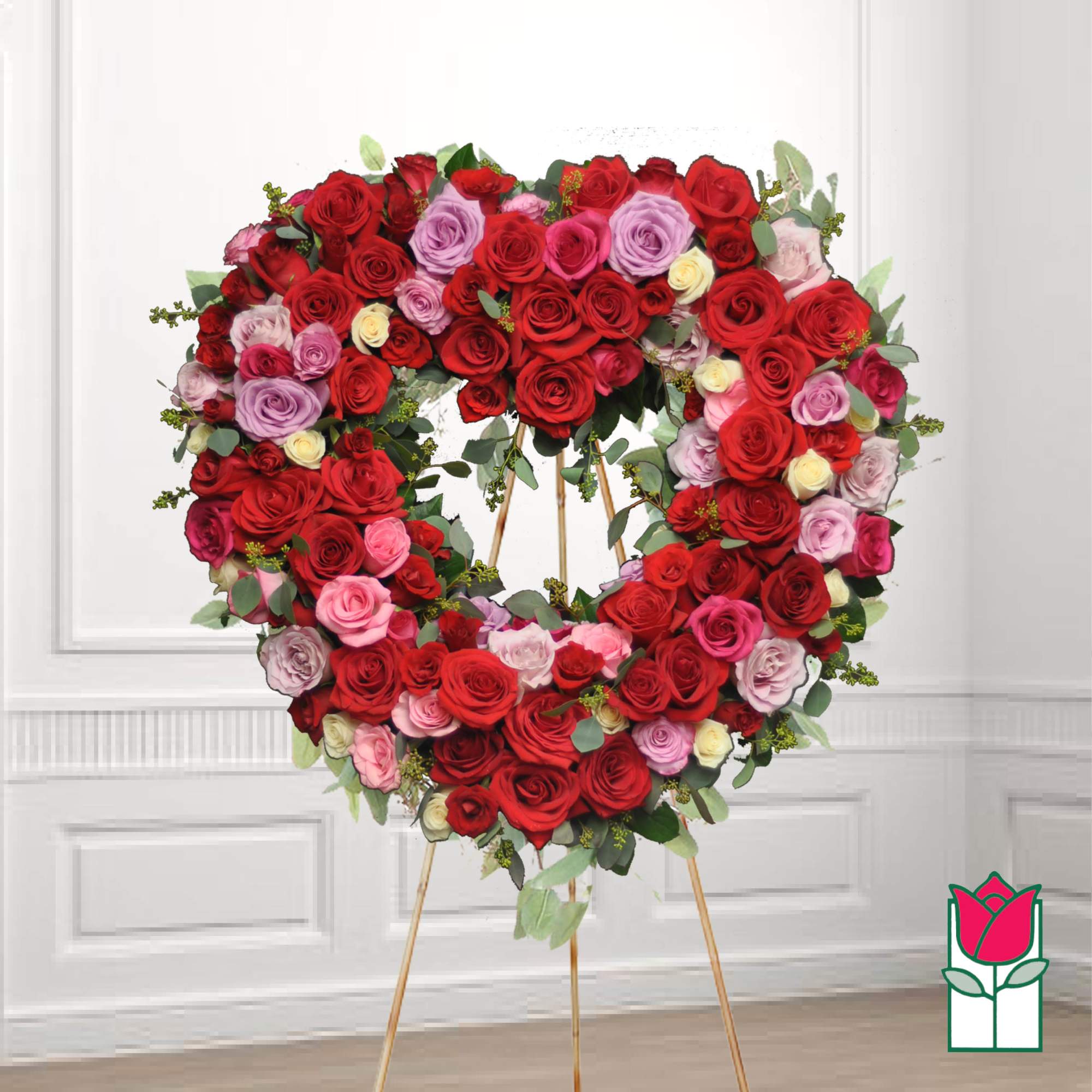 Heart-shaped wreath of red, pink, and lavender roses on an easel