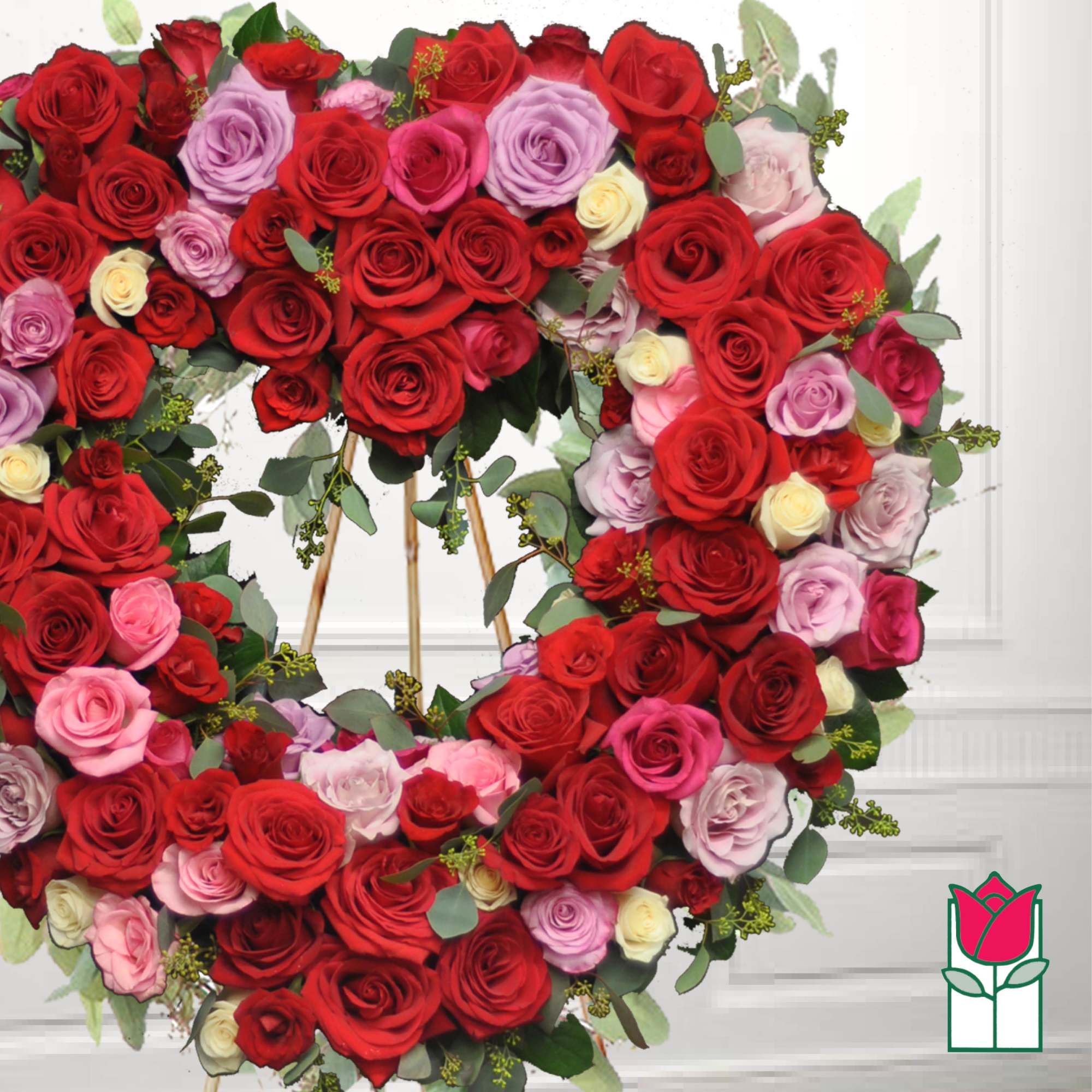 Heart-shaped wreath of red, pink, and lavender roses