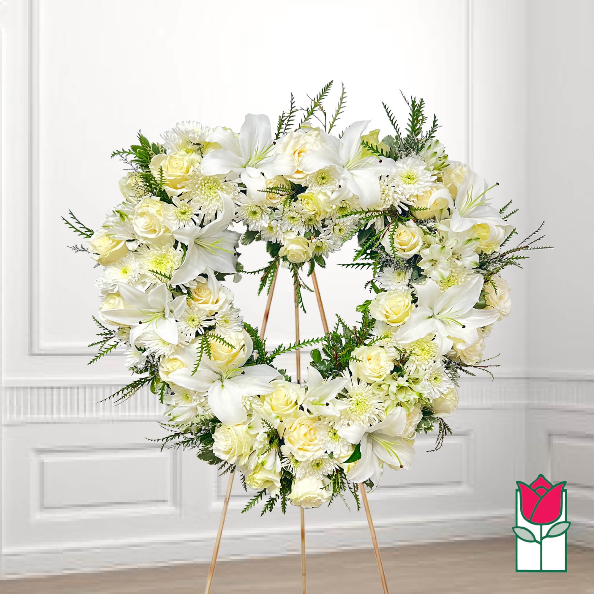 Heart-shaped floral wreath of white lilies and cream roses on an easel