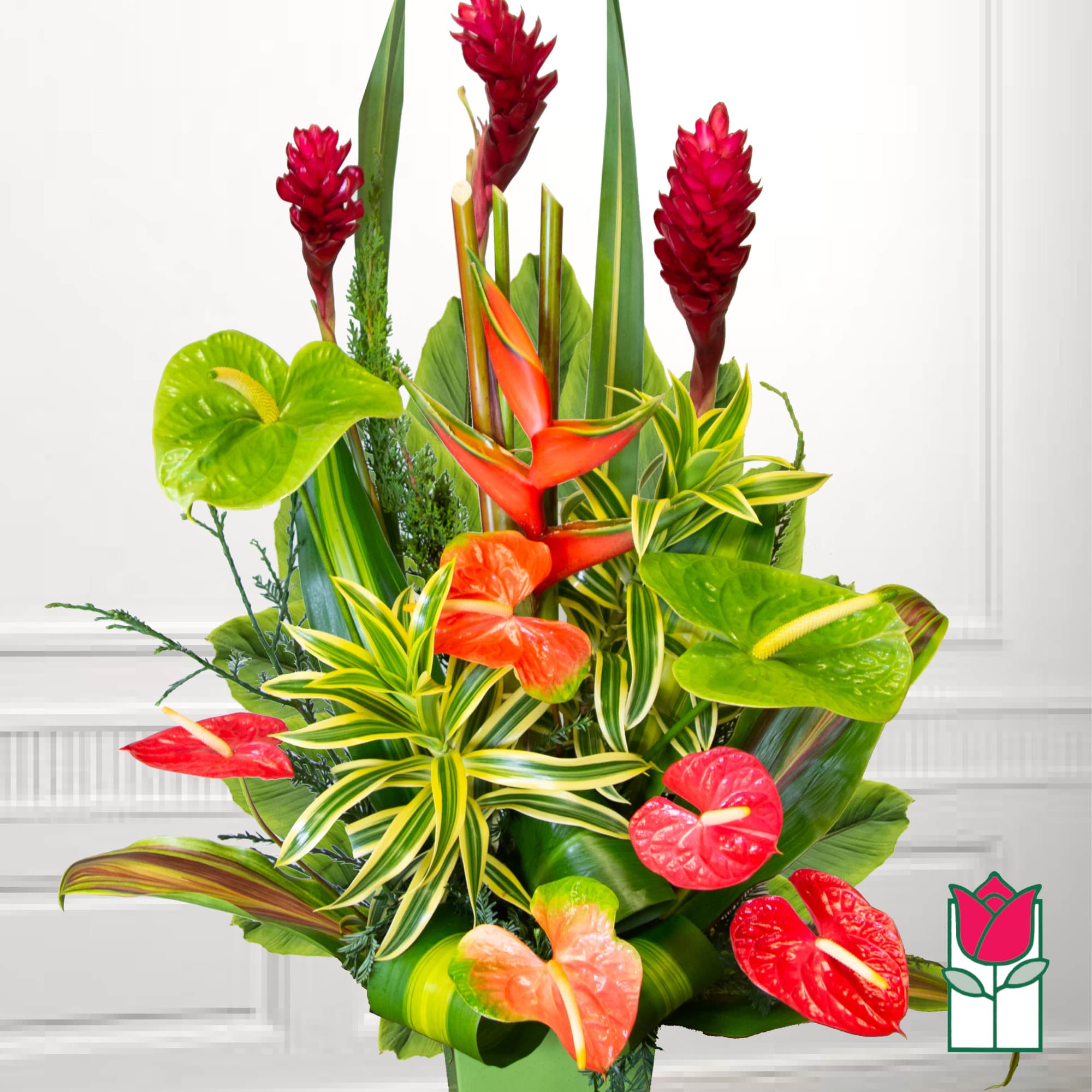 Tropical arrangement with red ginger, anthuriums, and variegated foliage
