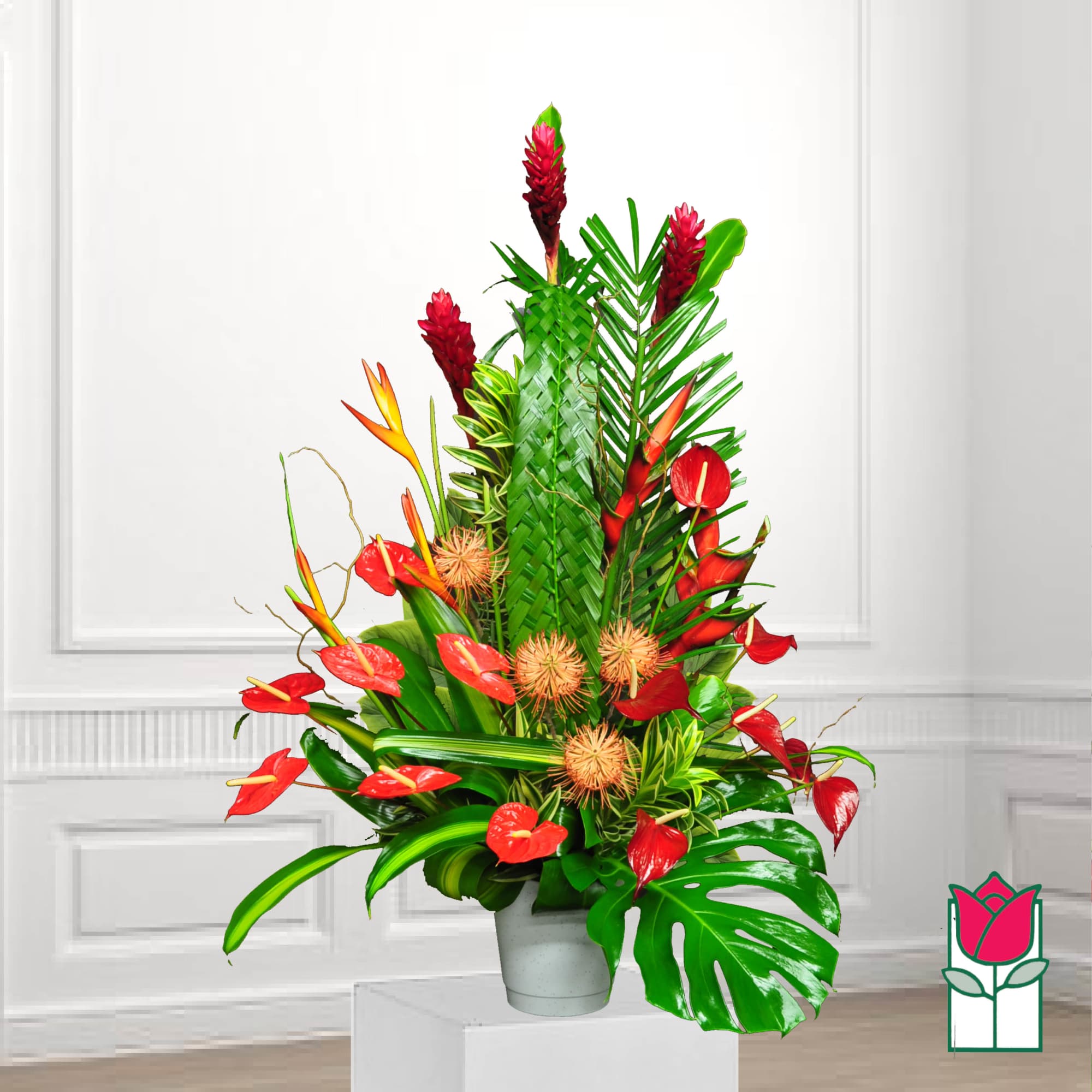 Tropical arrangement with red flowers in a gray pot