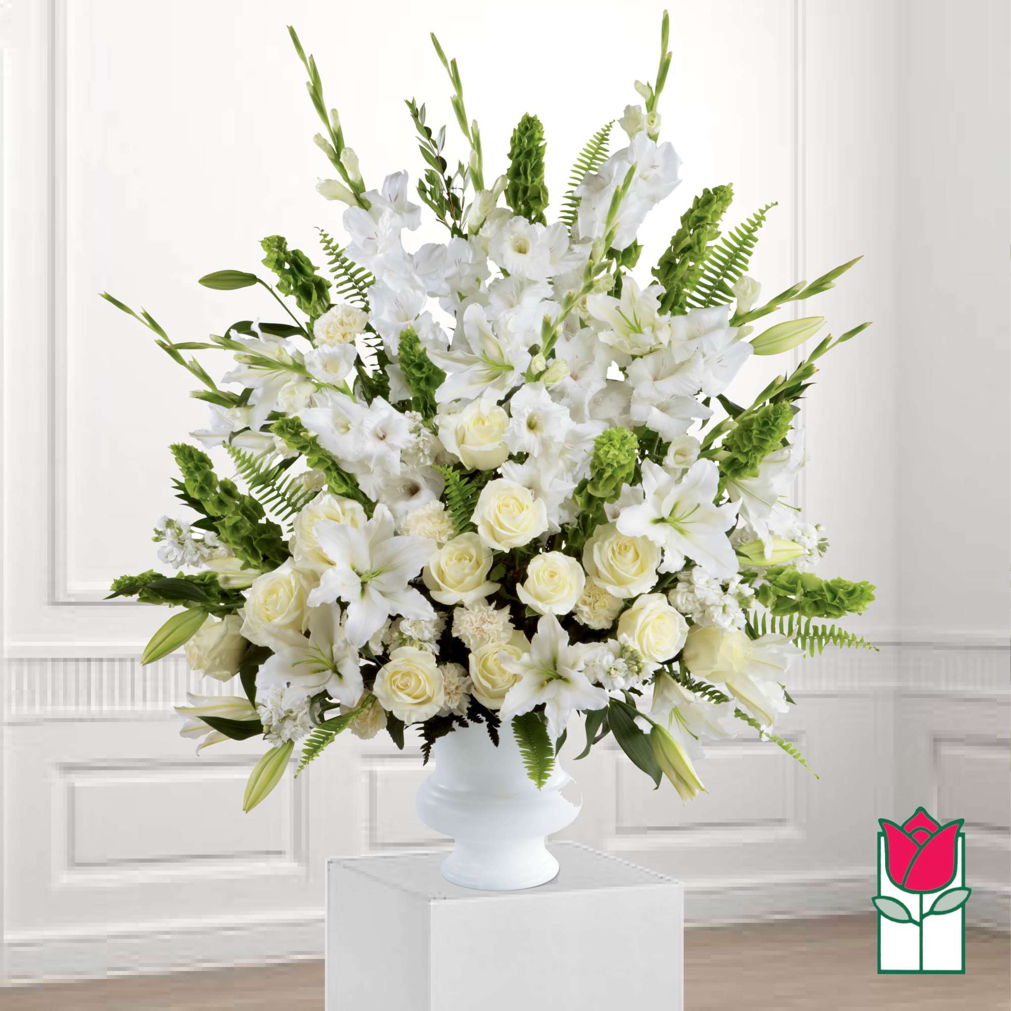 White floral arrangement in a white vase with lilies and roses