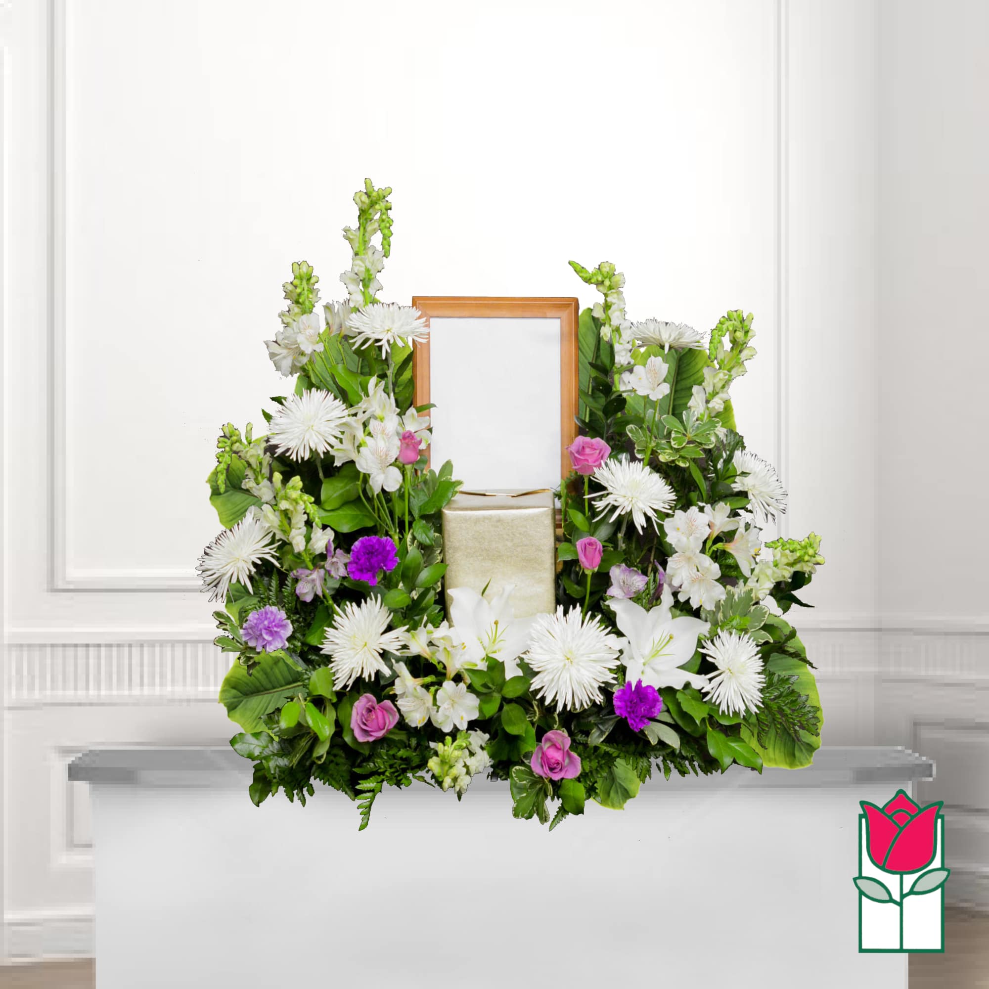 White and pink floral arrangement framing a wooden picture frame and gift box