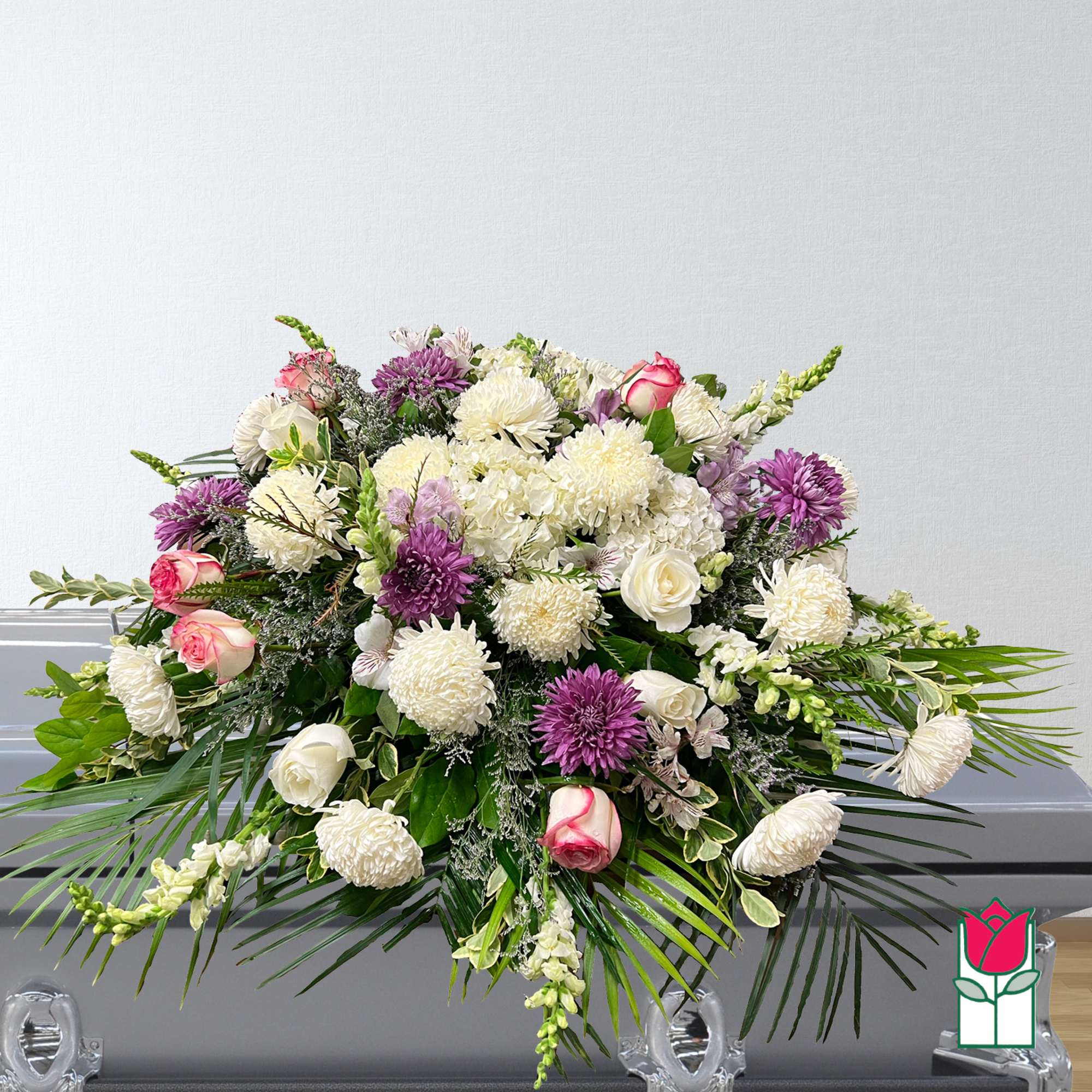 Large funeral spray with white and purple flowers and pink roses