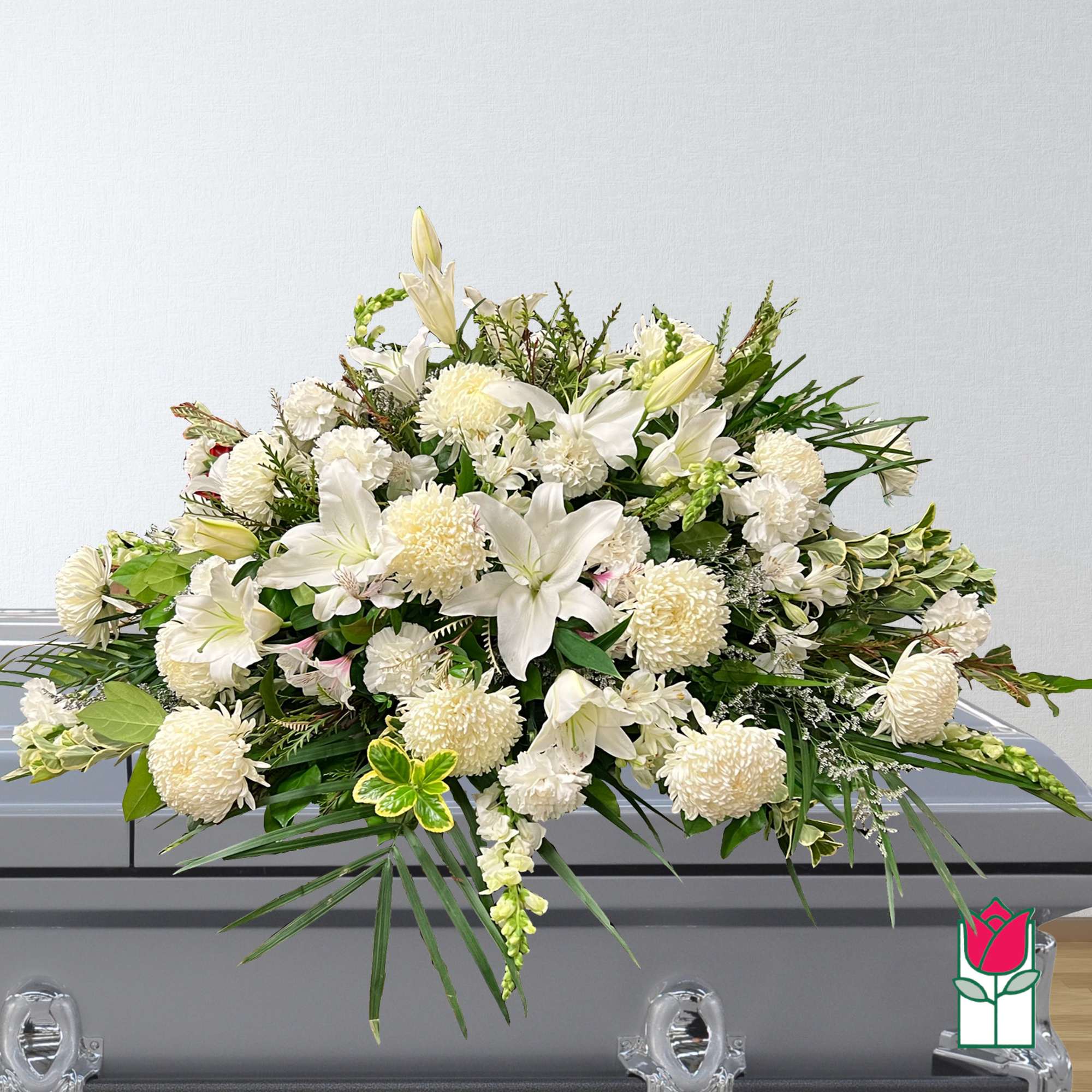 White floral casket spray with lilies and pompons
