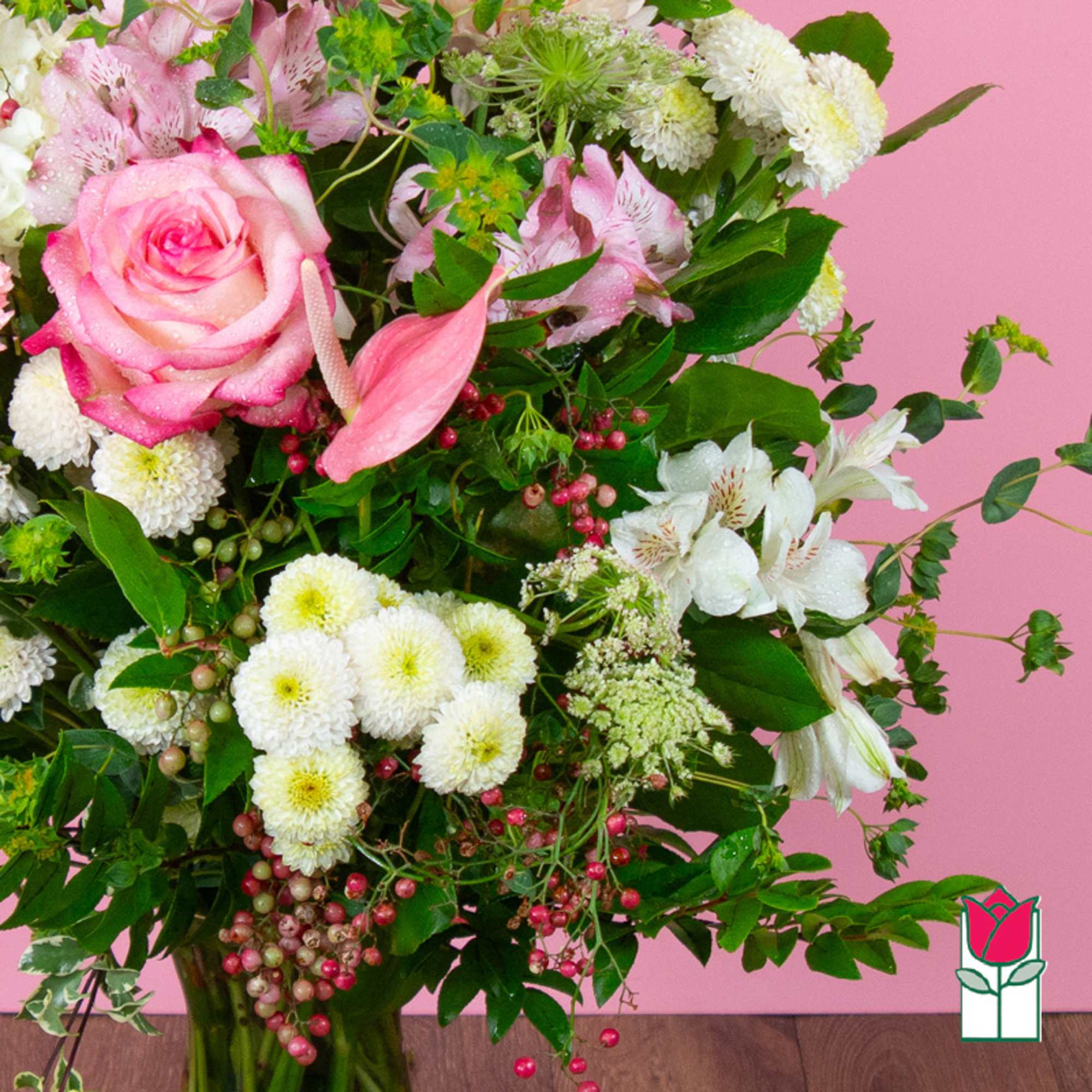 Pink roses and white flowers arranged in a glass vase