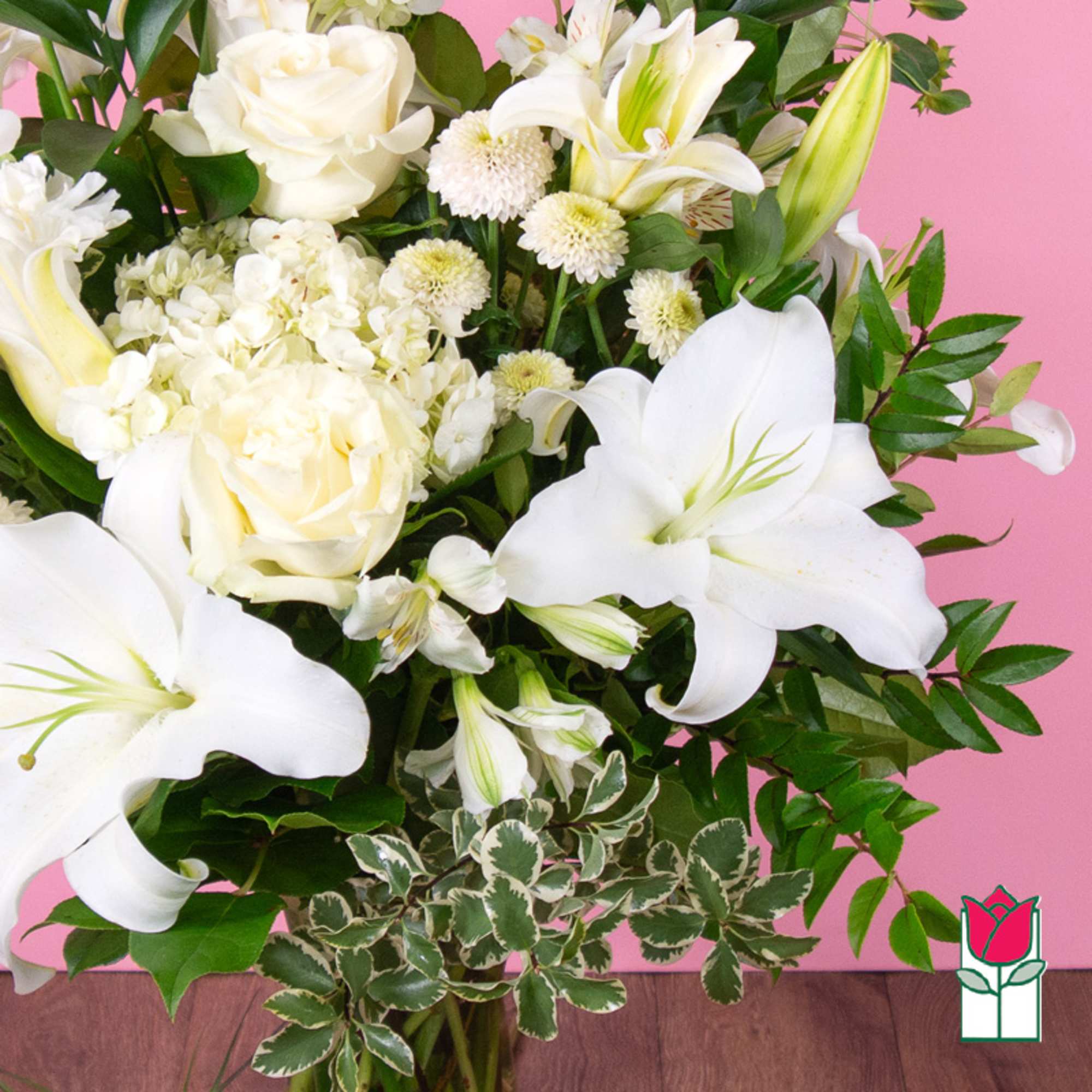White lilies and roses in a lush bouquet with green foliage