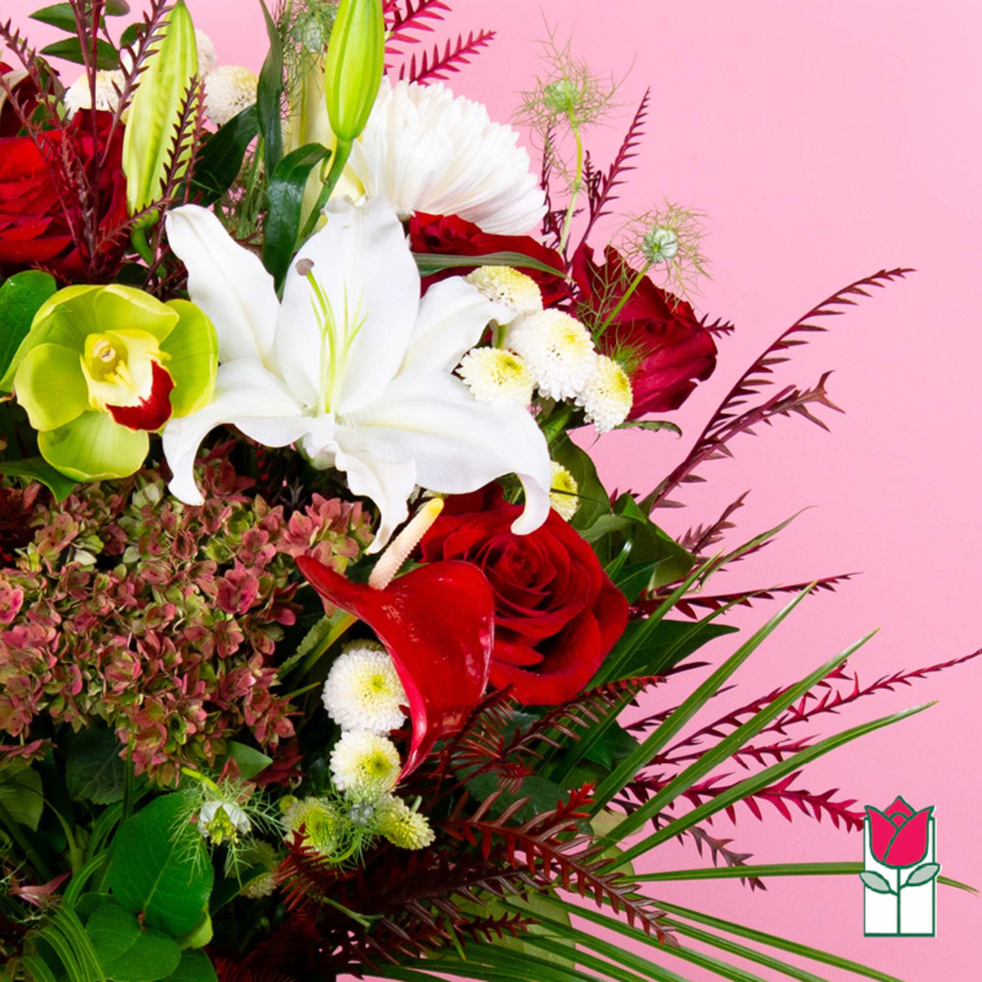 Red and white floral arrangement with lilies, roses, and orchids