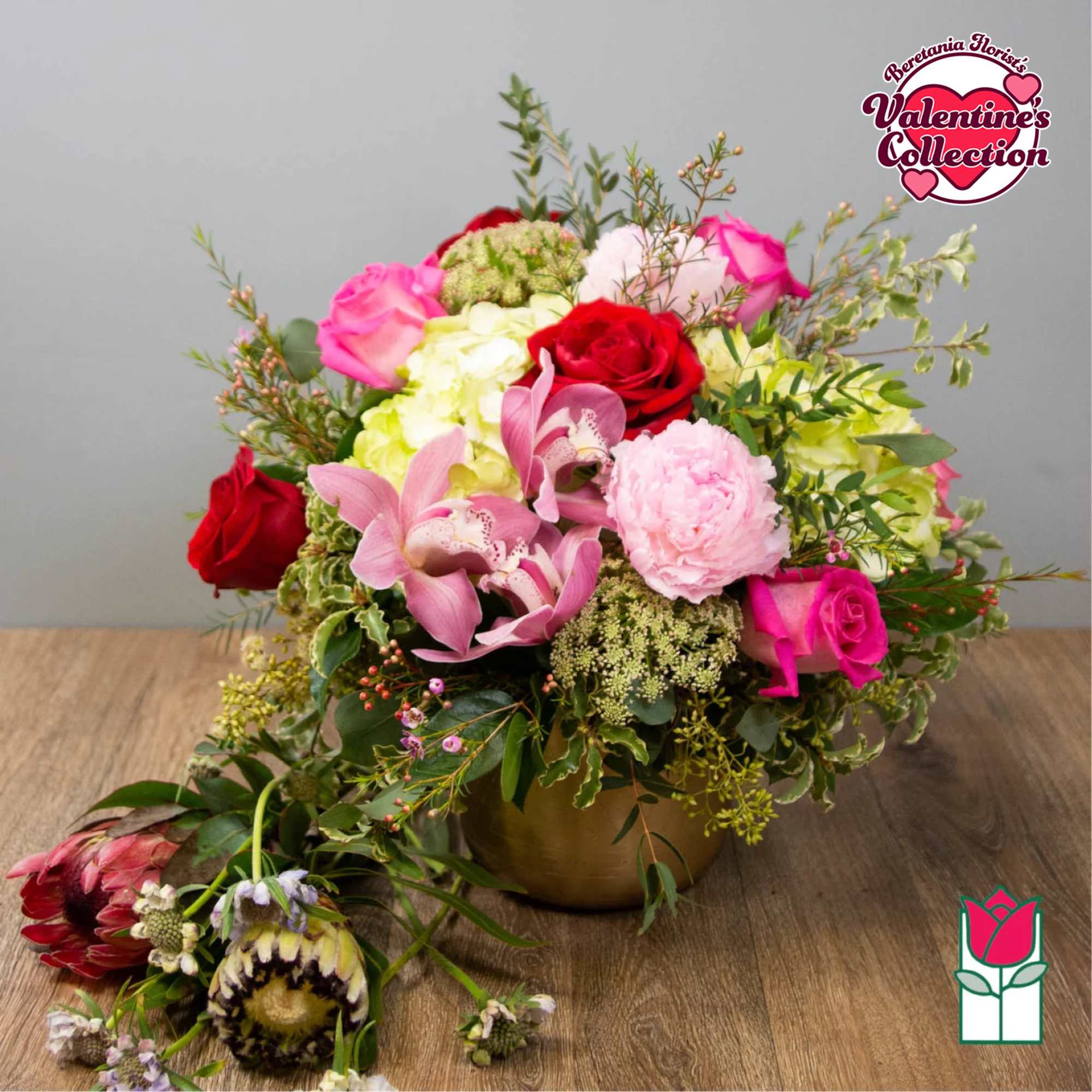 Mixed bouquet of roses, orchids, and pink blooms in a gold vase, photo 5 of 5