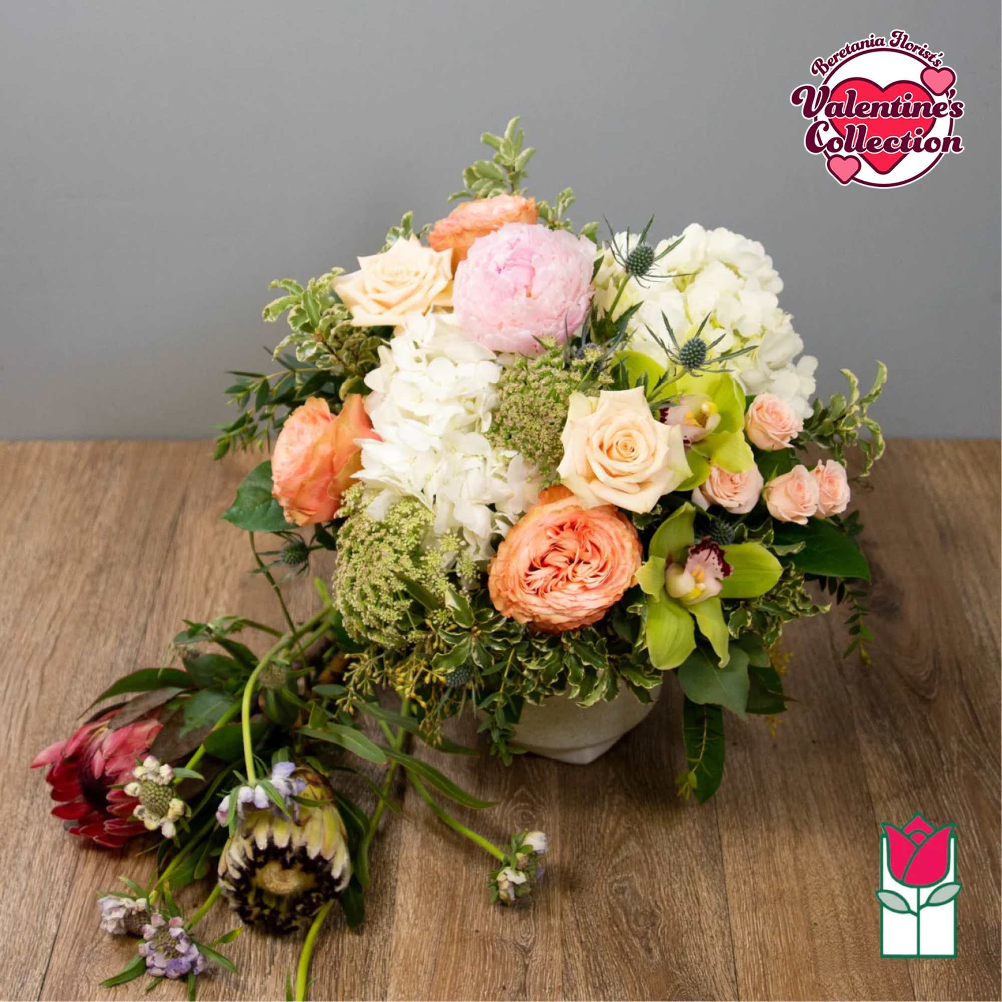 Mixed bouquet with peach, pink, and white flowers in a low vase
