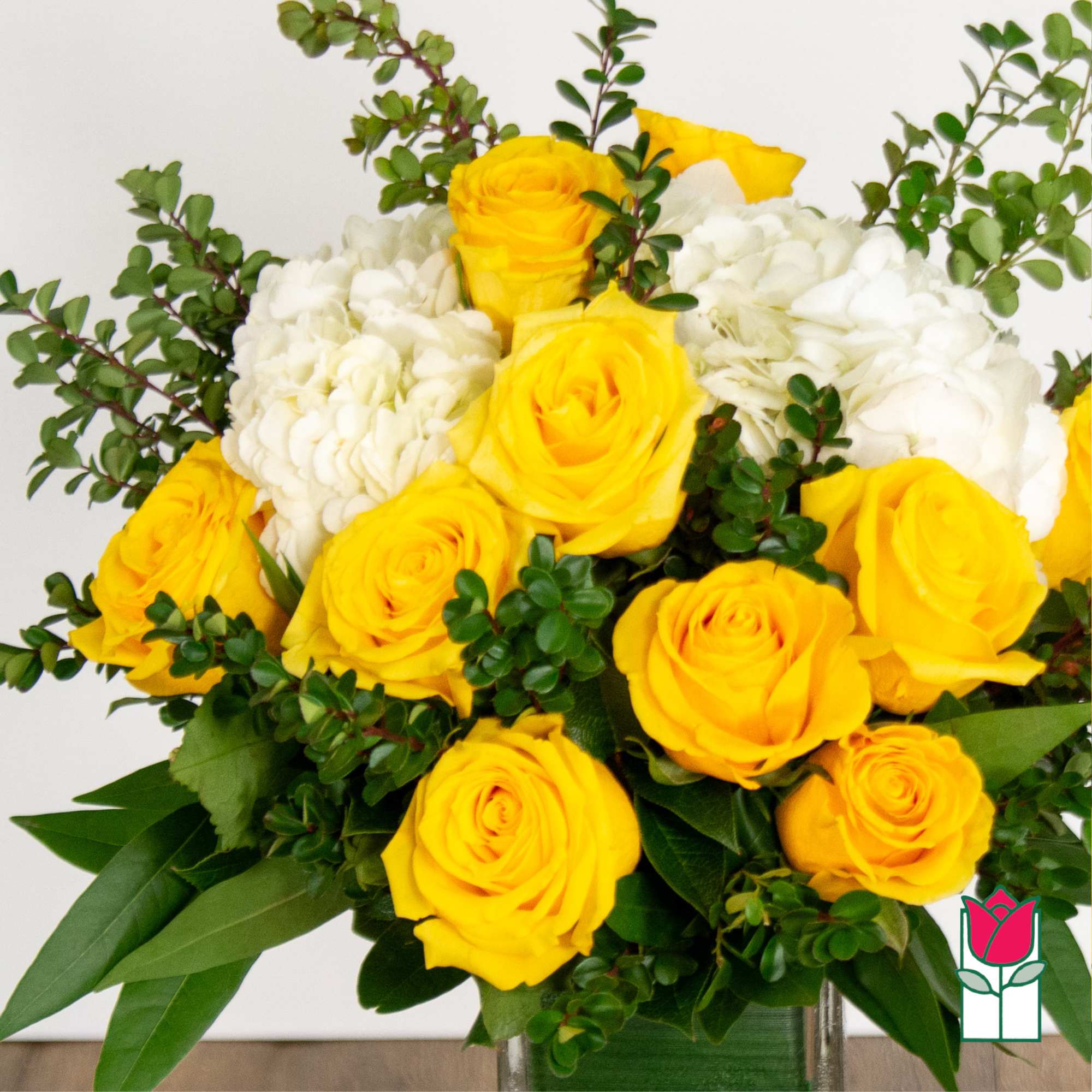Bouquet of yellow roses and white hydrangeas in a glass vase