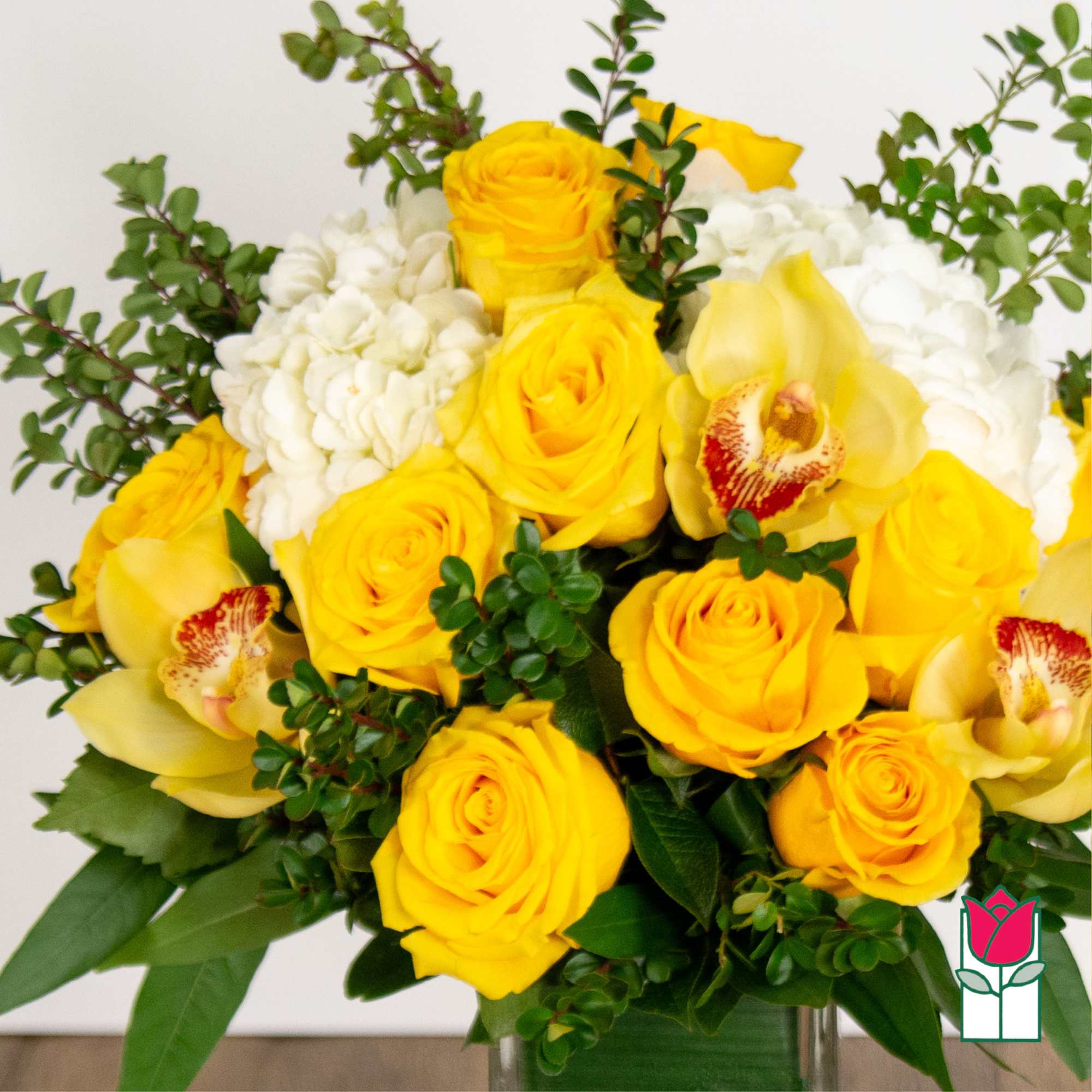 Bouquet of yellow roses, white hydrangeas, and yellow orchids in a vase