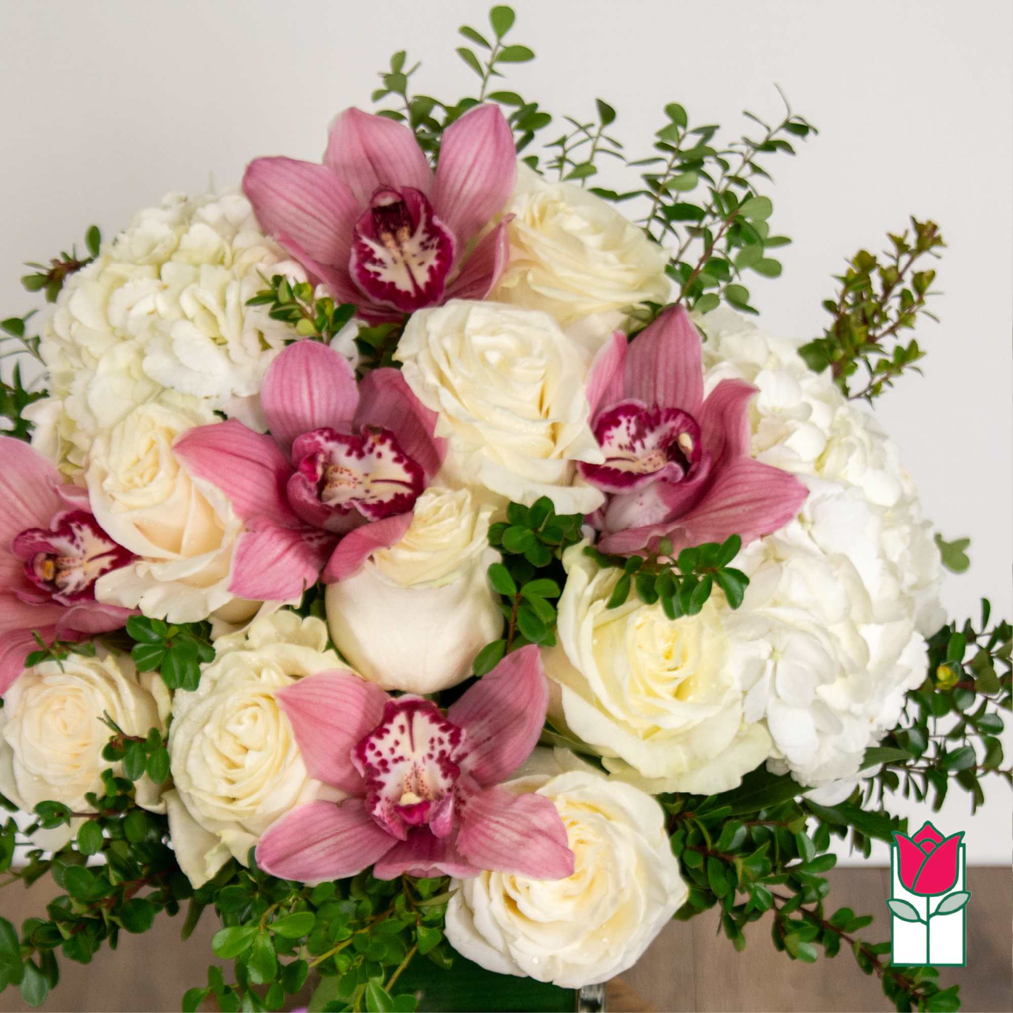 Bouquet of white roses, hydrangeas, and pink orchids with greenery